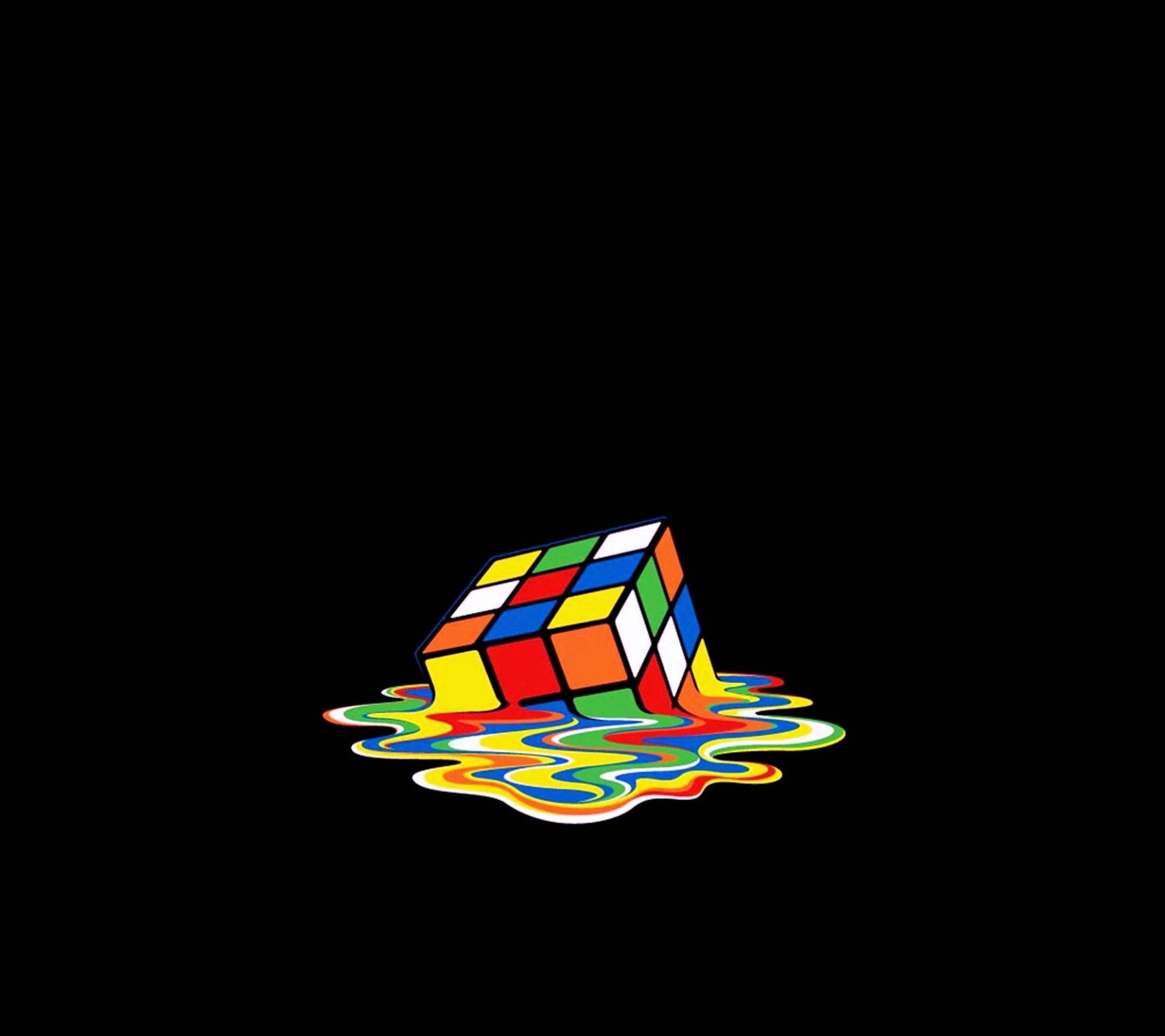 AMOLED 桌布 壁紙 — 一個融化的魔術方塊在黑色背景上滴落鮮豔的色彩，呈現超現實的數位藝術風格。