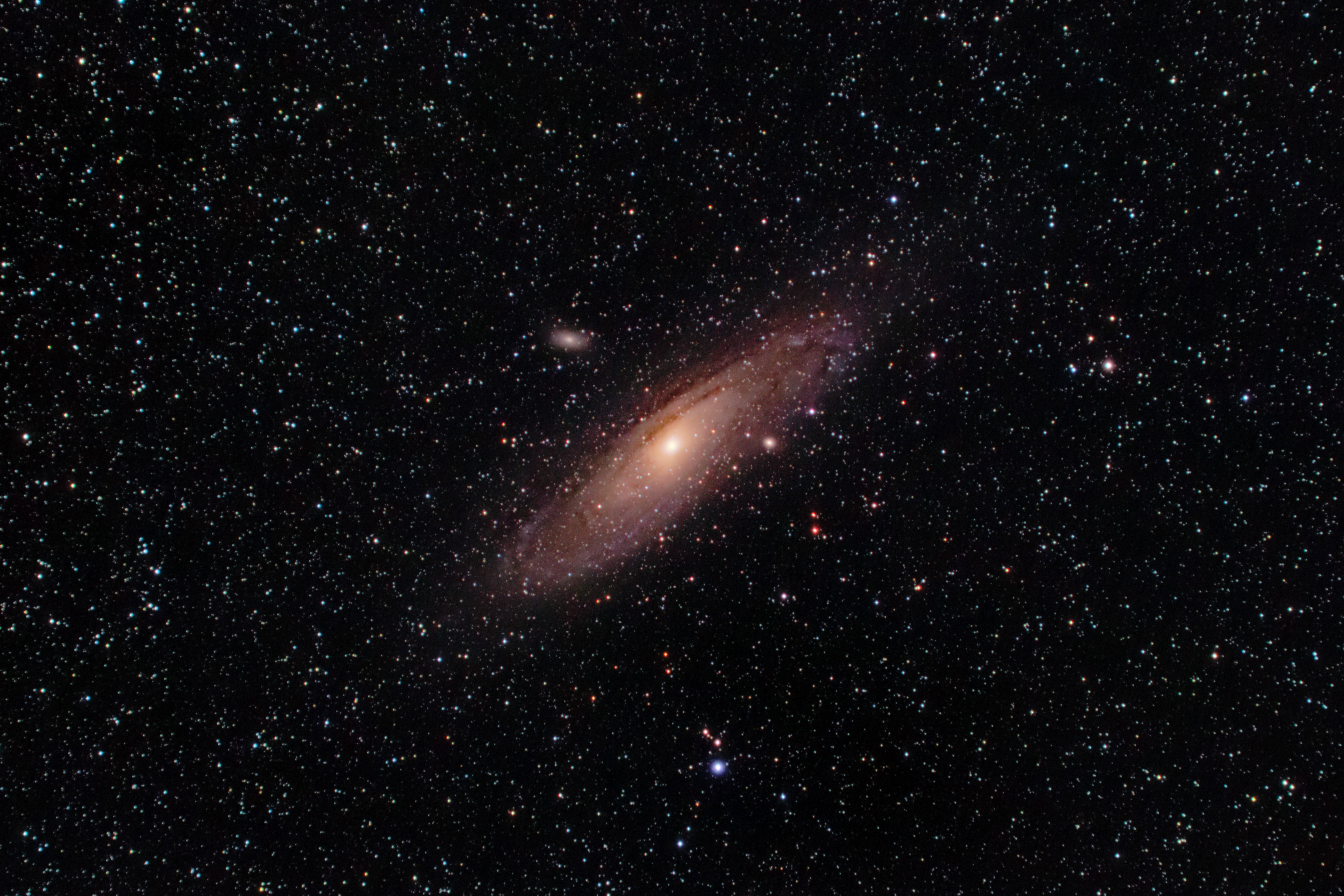 Stars 桌布 壁紙 — 一個螺旋星系在深邃黑色太空的無數閃爍星星背景下，散發著溫暖的橙色和粉紅色調。