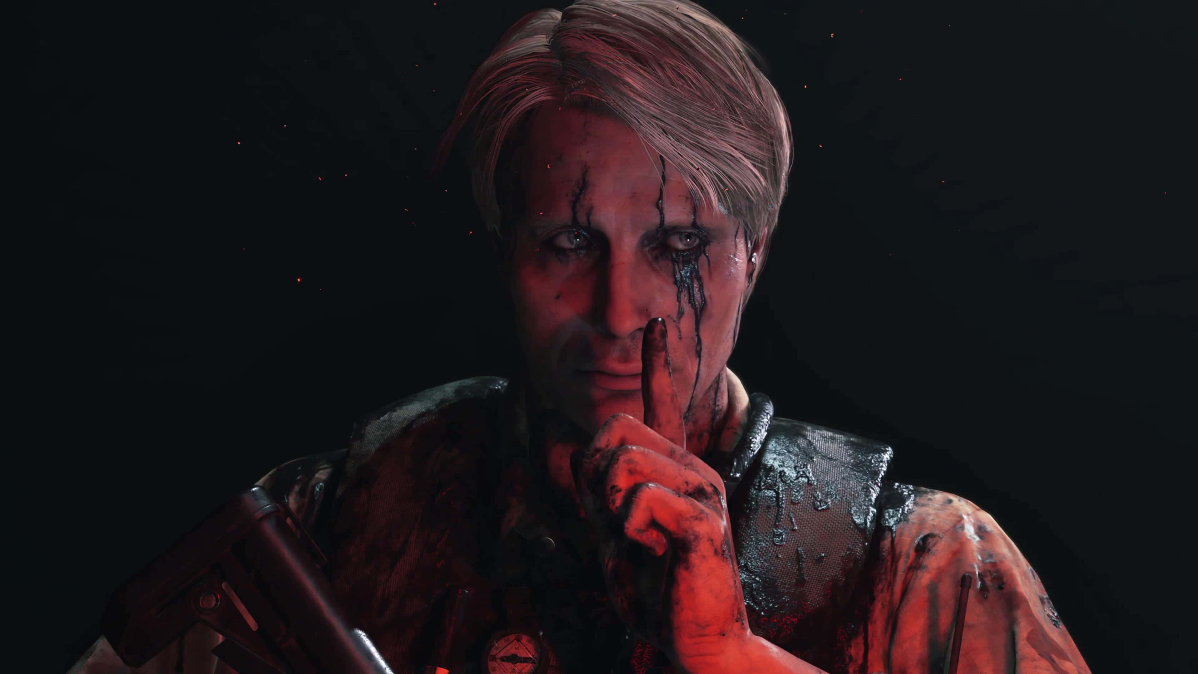 Death Stranding Desktop 桌布 壁紙 — 一個血跡斑斑的男人將手指放在唇邊，在黑暗背景中帶有發光紅色點綴下強烈凝視。