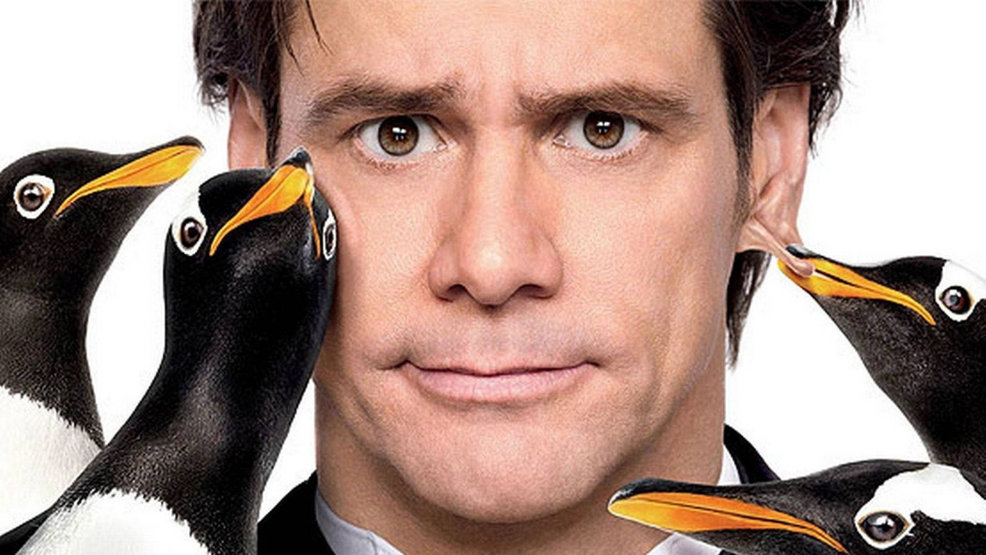 Jim Carrey 桌布 壁紙 — 一個表情驚訝的男人，有四隻企鵝好奇地啄他的臉，背景為白色。