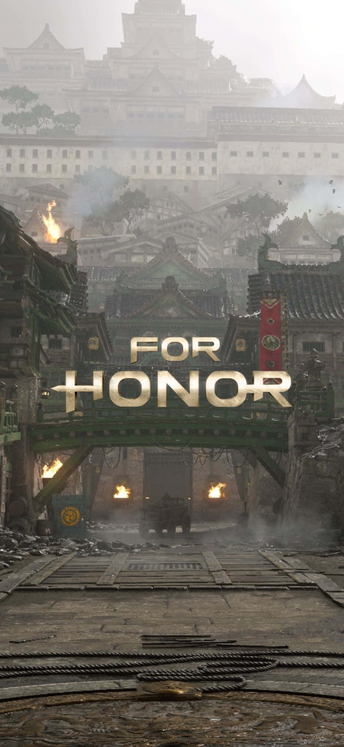 iPhone Xs For Honor 桌布 壁紙 — 一個被戰爭摧毀的日本城堡小鎮，燃燒的火把和一個金色的「FOR HONOR」標誌在霧濛濛的天空下。