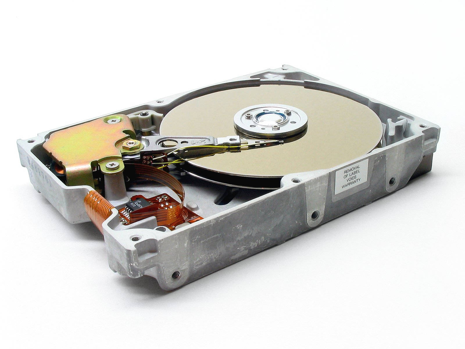 Hard Drive 桌布 壁紙 — 一個被拆解的硬碟驅動器，在純白背景下顯露出其內部的碟片、讀寫頭和電路。