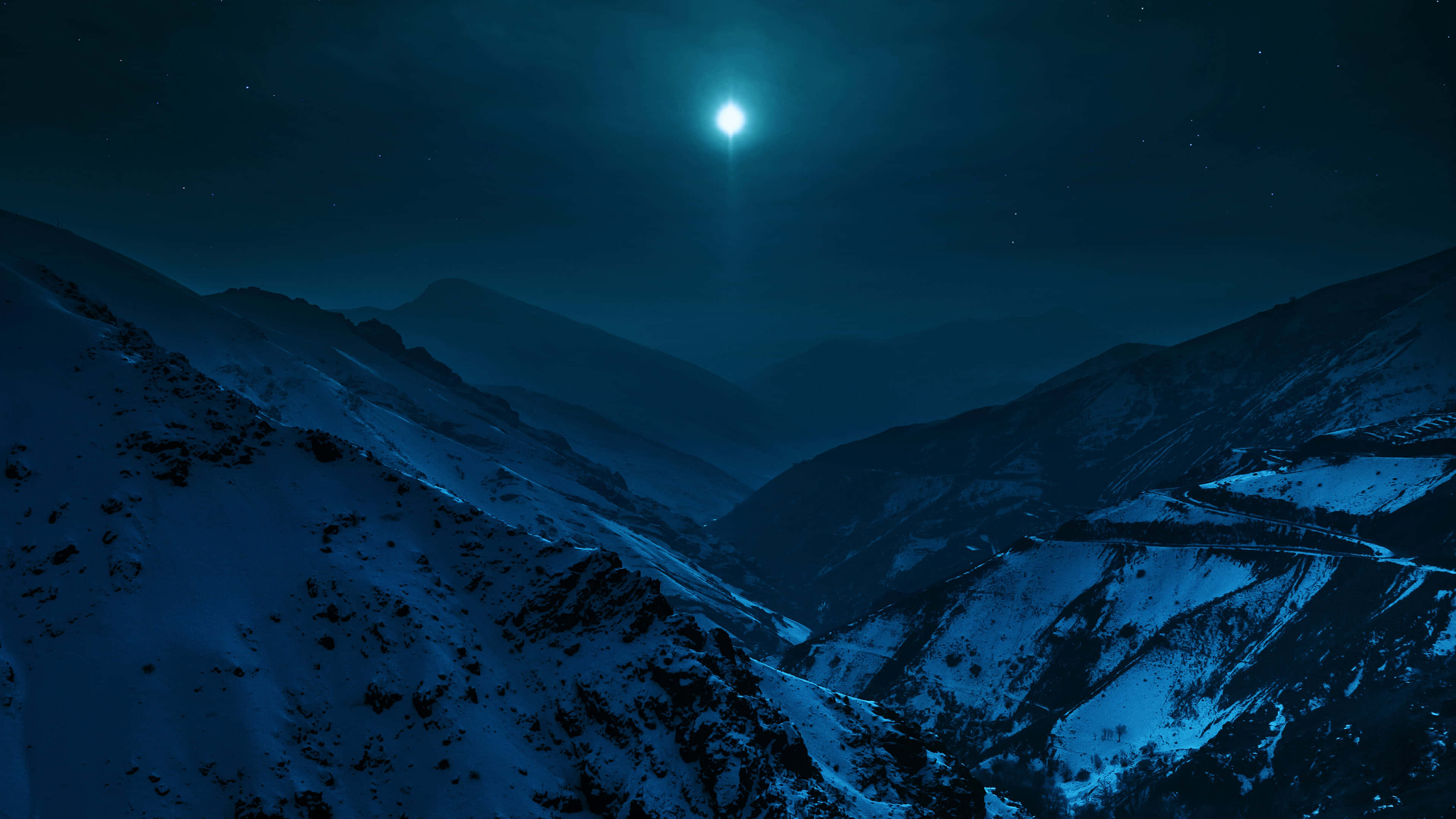 Dark Sky 桌布 壁紙 — 一個被白雪覆蓋的山谷，沐浴在明亮月亮的冷光下，星空璀璨。