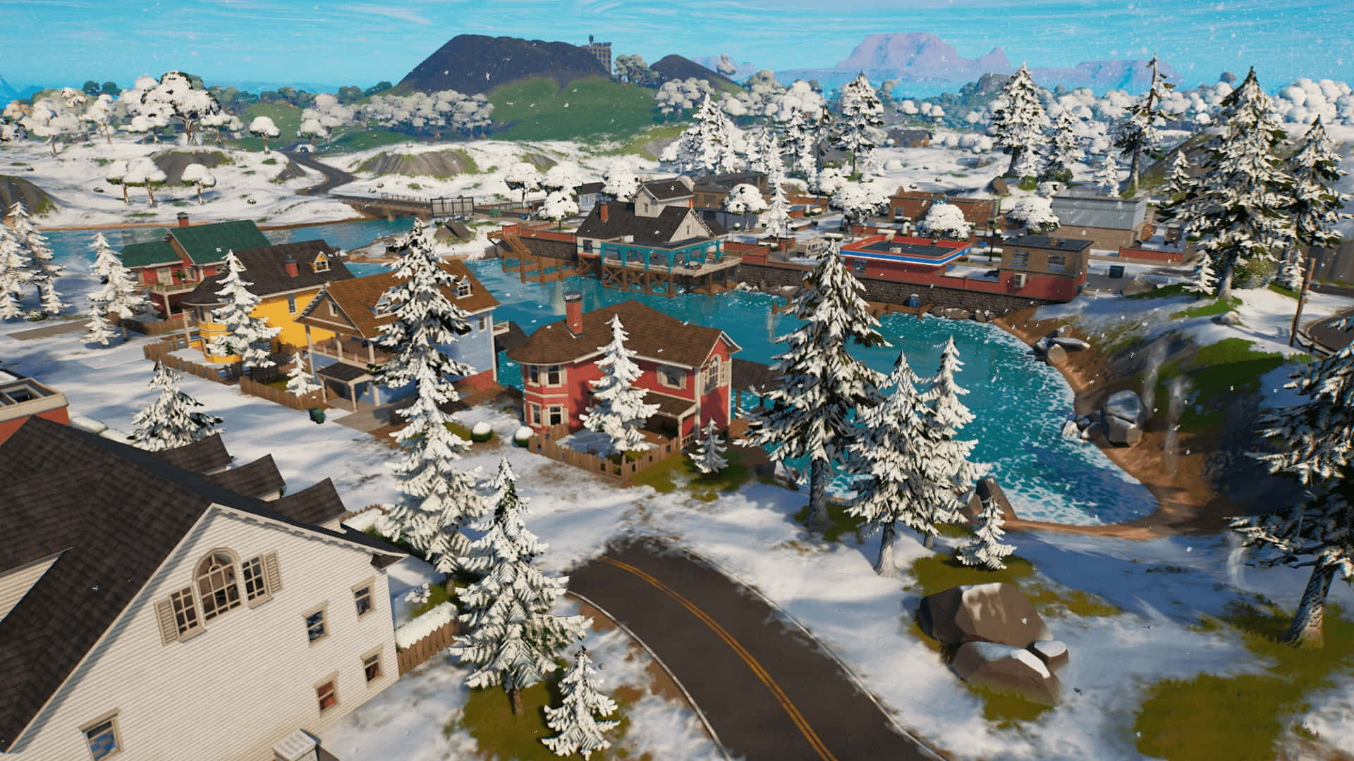 Fortnite Chapter 3 桌布 壁紙 — 一個被白雪覆蓋的村莊，色彩繽紛的房屋坐落在明亮的藍色河流旁，周圍是常綠樹木和遠處的山脈，天空清澈湛藍。