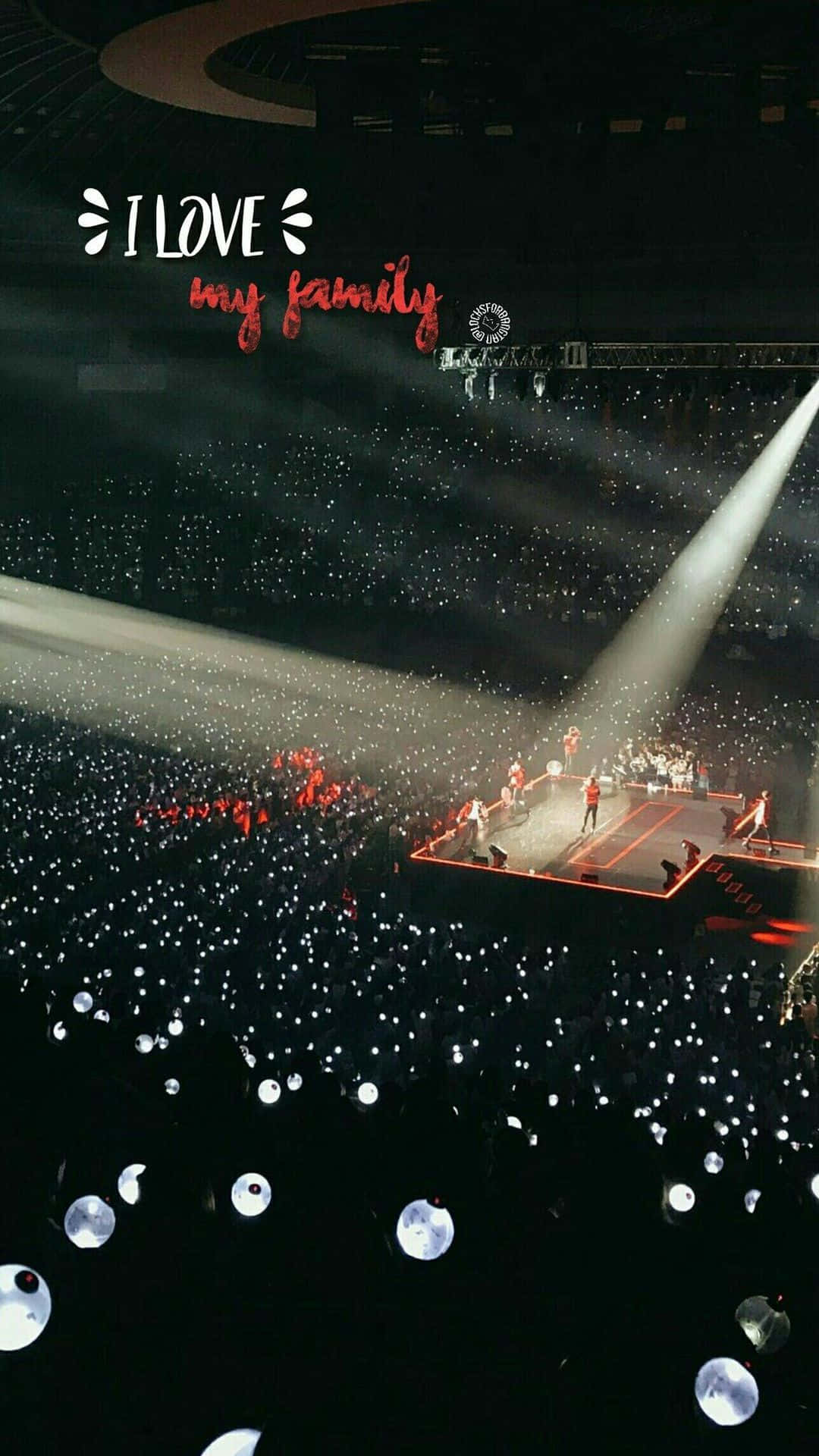 Bts Army Bomb 桌布 壁紙 — 一個被聚光燈籠罩的演唱會舞台，下方觀眾舉起一片發光的手機燈海。