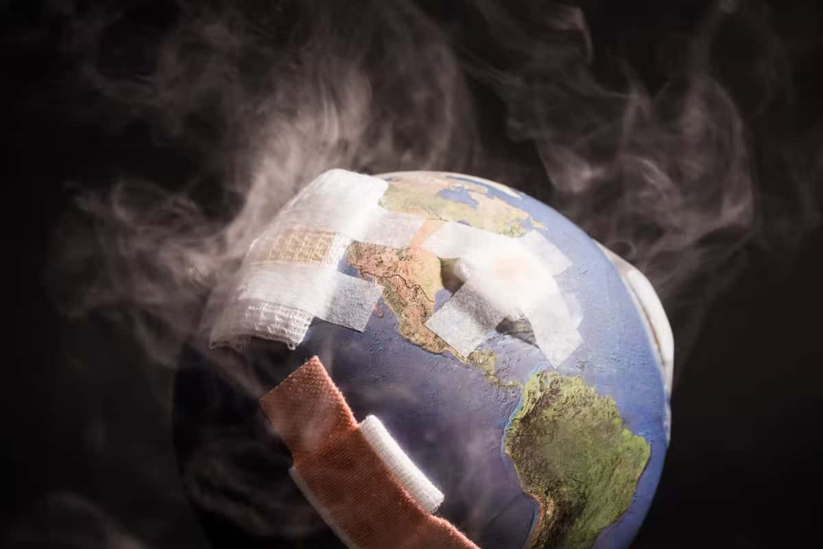 地球 桌布 壁紙 — 一個被醫療繃帶覆蓋並在黑暗背景下冒煙的地球儀。