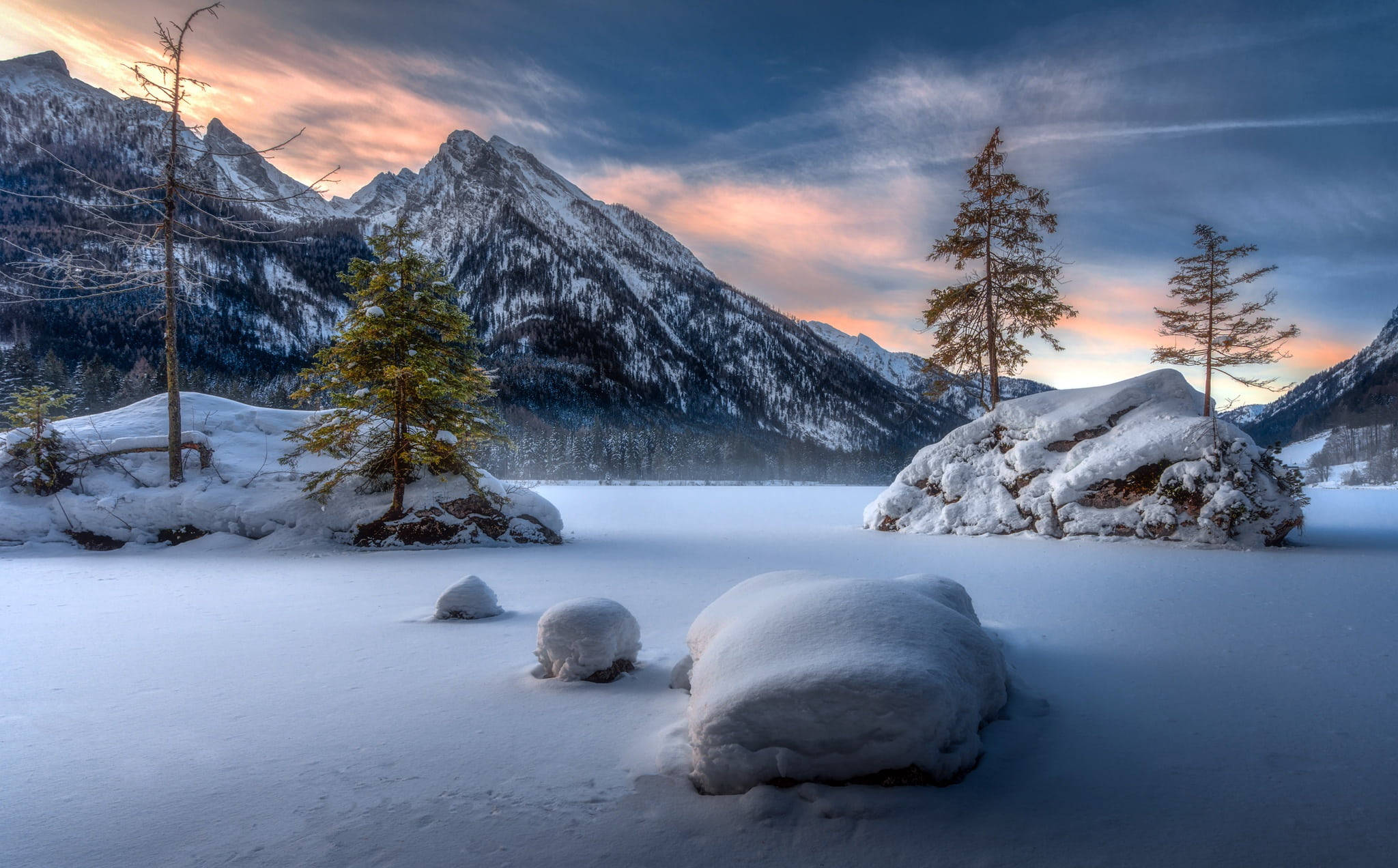Landscapes 桌布 壁紙 — 一個被雪覆蓋的冰凍湖泊，白雪覆蓋的山脈和常青樹在戲劇性的暮色天空下。