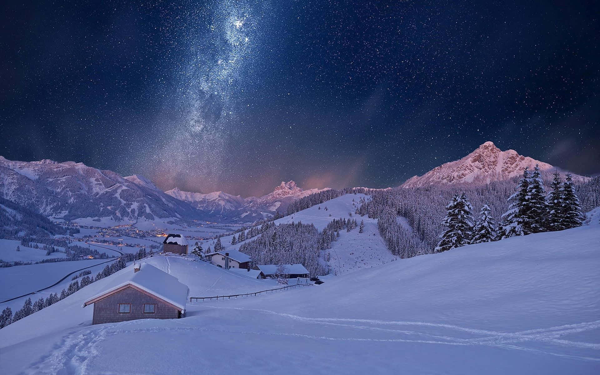 冬季桌面 桌布 壁紙 — 一個被雪覆蓋的山村，在充滿活力的星空下，銀河拱橋般橫跨天際。