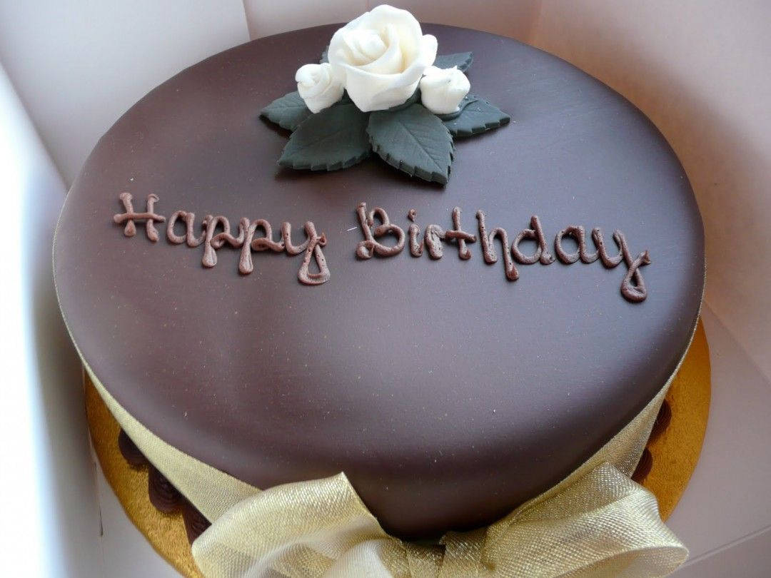 Birthday Cake 桌布 壁紙 — 一個裝在盒子裡、飾有白玫瑰和金色絲帶的濃郁巧克力生日蛋糕。