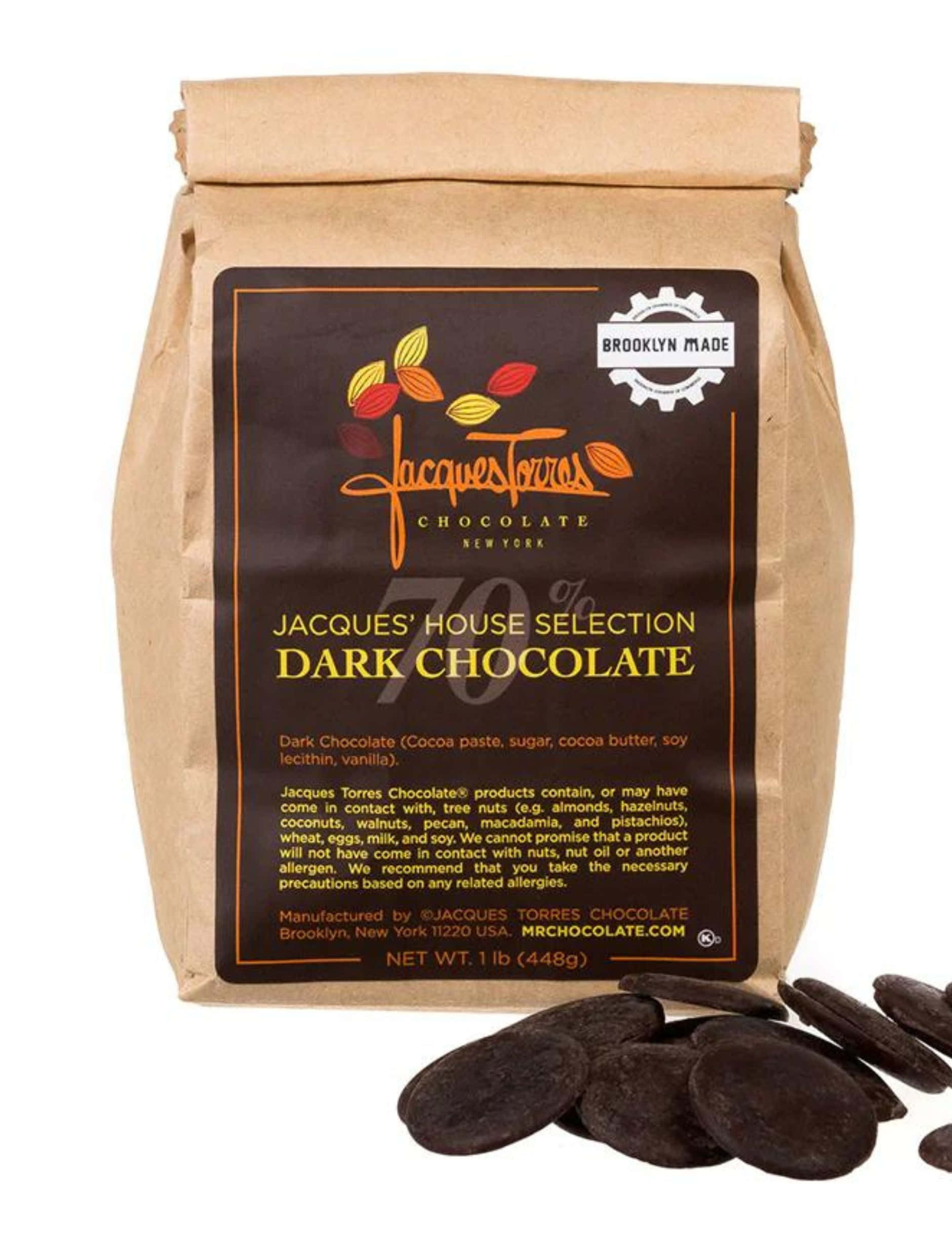 Dark Chocolate 桌布 壁紙 — 一個裝有Jacques Torres 70%黑巧克力的棕色紙袋，白色背景上散落著巧克力圓片。