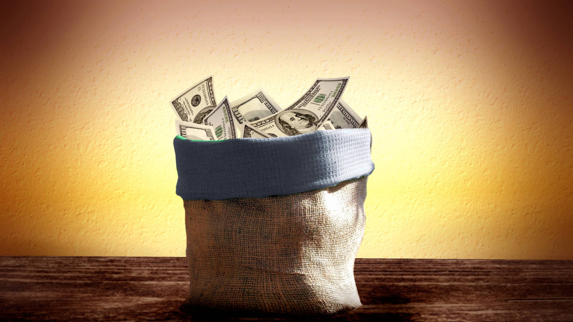 Money 桌布 壁紙 — 一個裝滿清脆美元鈔票的粗麻布袋，放在木質表面上，背景是溫暖的漸變牆。