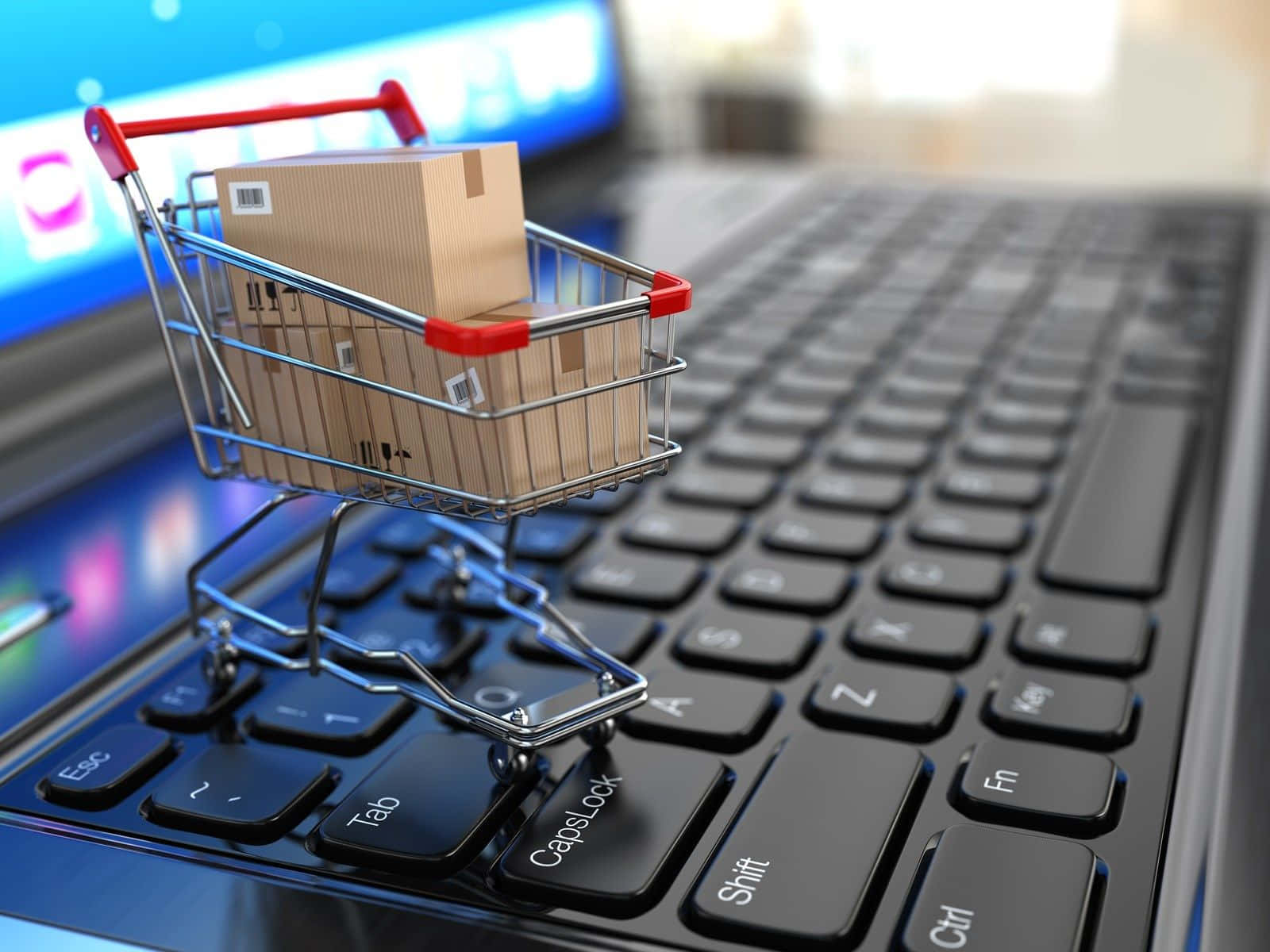 Shopping 桌布 壁紙 — 一個裝滿紙箱的微型購物車放在發光螢幕背景的筆記型電腦鍵盤上。