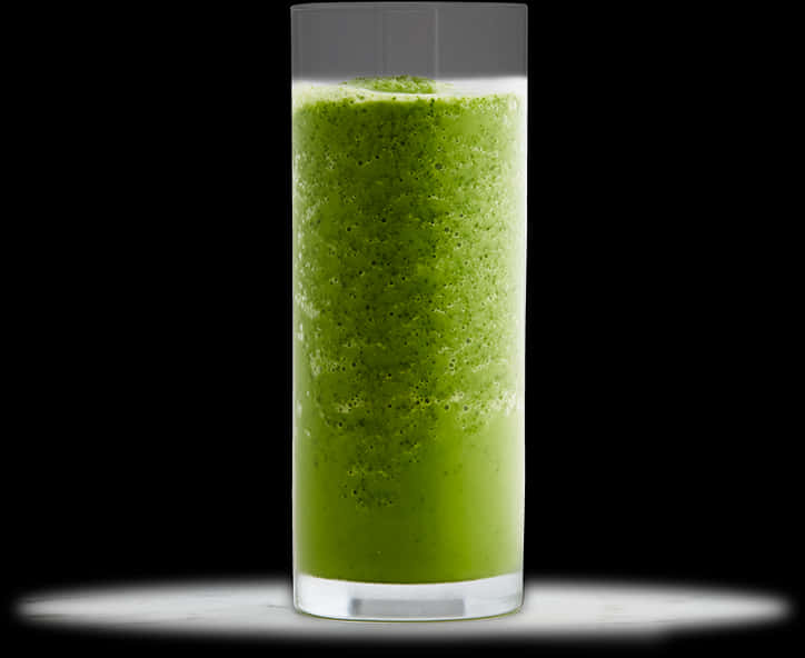 Smoothies 桌布 壁紙 — 一個裝滿鮮綠色冰沙的高腳杯，在黑色背景中央，下方有柔和的白光照明。