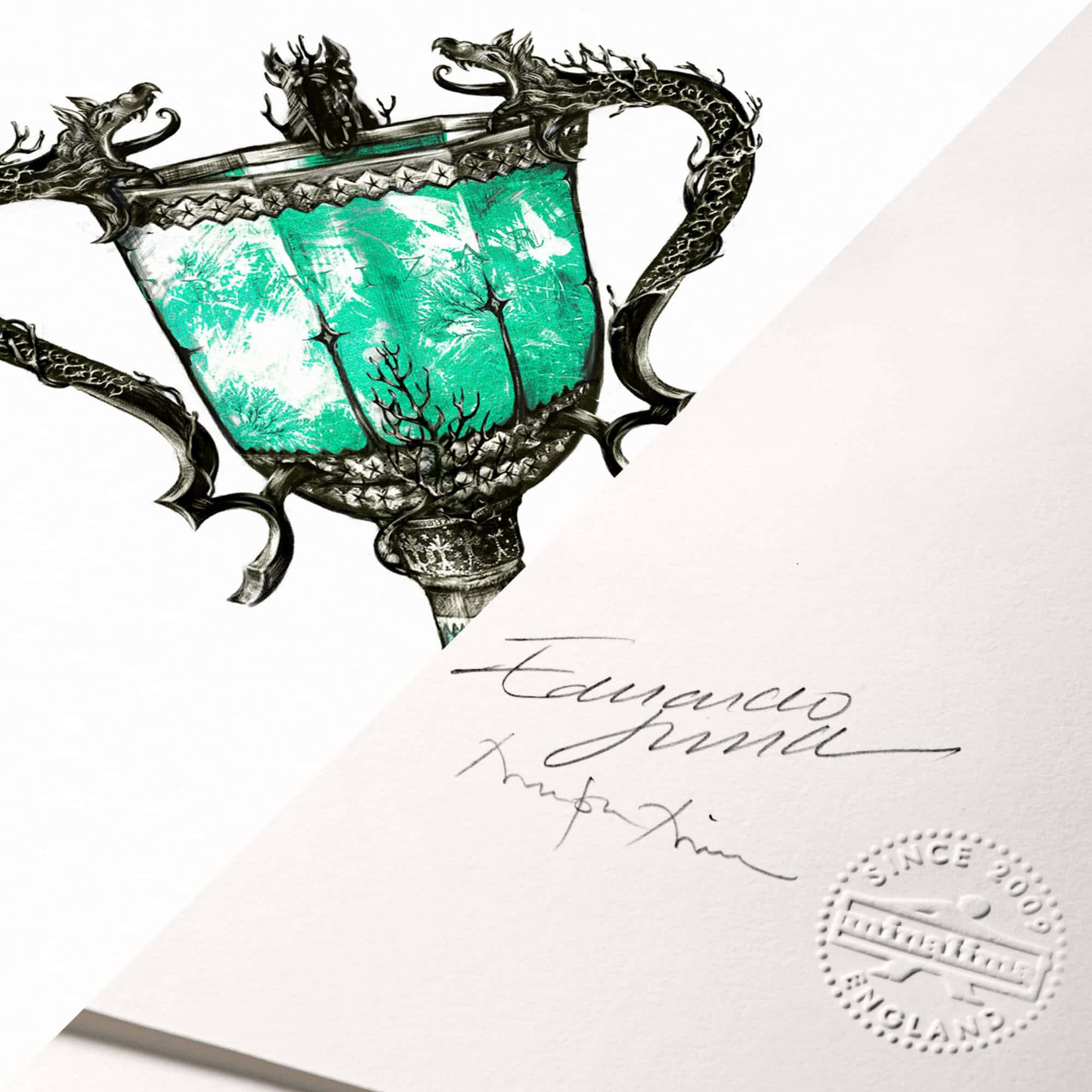 The Triwizard Cup 桌布 壁紙 — 一個裝飾華麗的銀獎盃，帶有龍形把手，其碗部包含一個充滿活力的藍綠色森林場景。