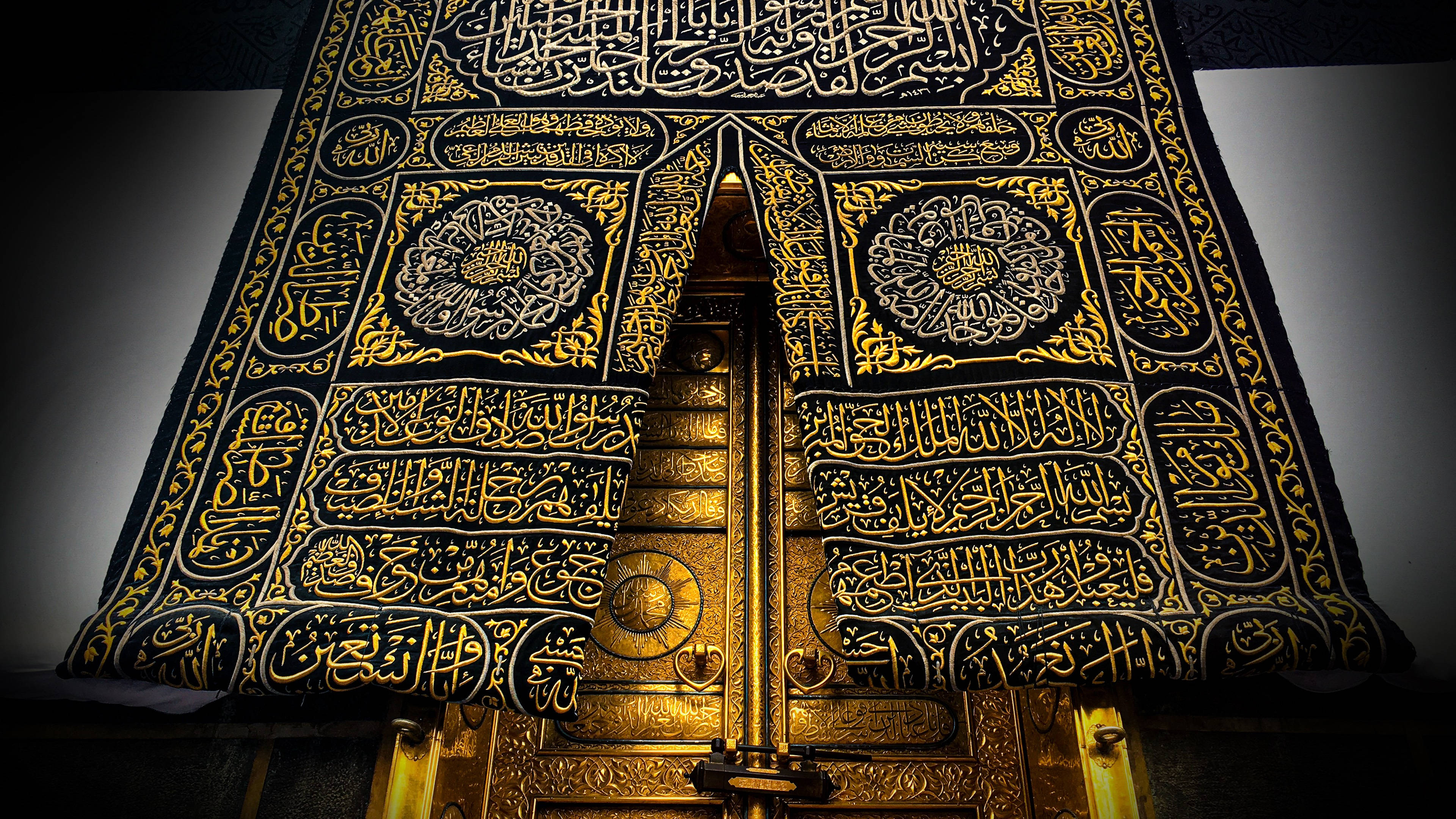 muslim 桌布 壁紙 — 一個裝飾華麗的黑色和金色伊斯蘭祈禱簾的近距離特寫，帶有複雜的書法和幾何圖案。