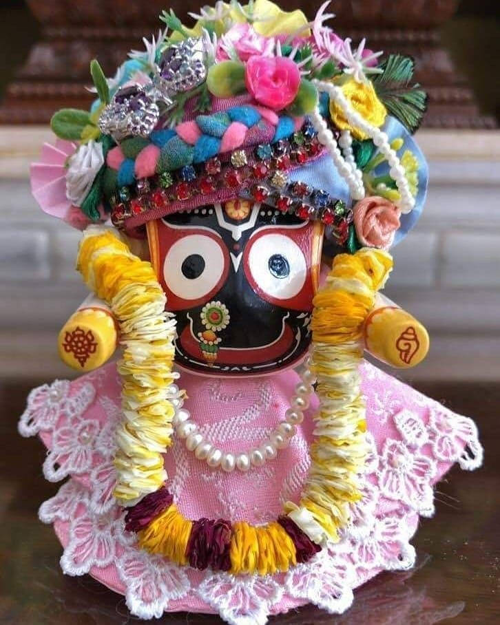 Jagannath 桌布 壁紙 — 一個裝飾鮮豔的傳統印度神像，飾有彩色花朵珠子和粉紅色蕾絲裙。