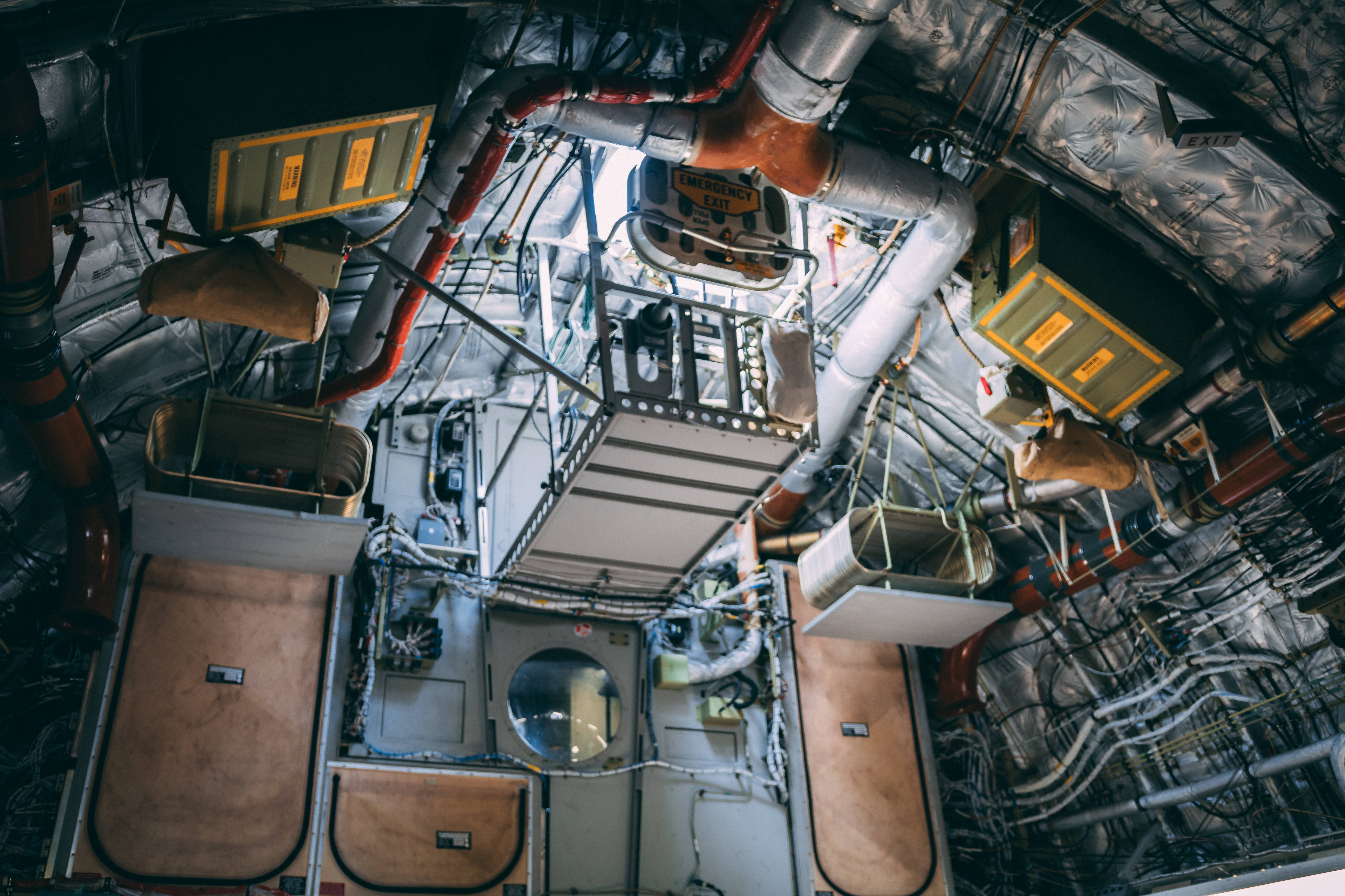 Aerospace 桌布 壁紙 — 一個複雜的太空船內部俯視圖，顯示在人工照明下暴露的管道、電線和設備。