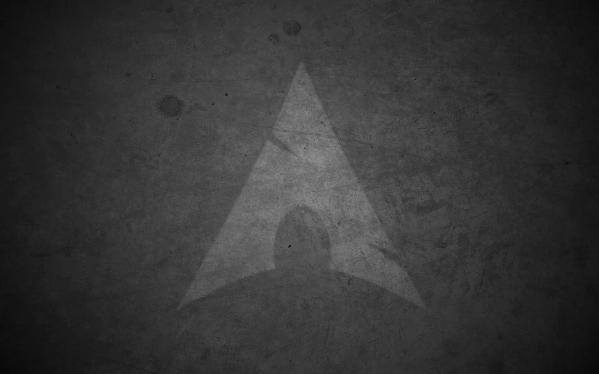 Linux 桌布 壁紙 — 一個褪色的三角形標誌蝕刻在粗糙紋理的牆壁上，採用單色調。