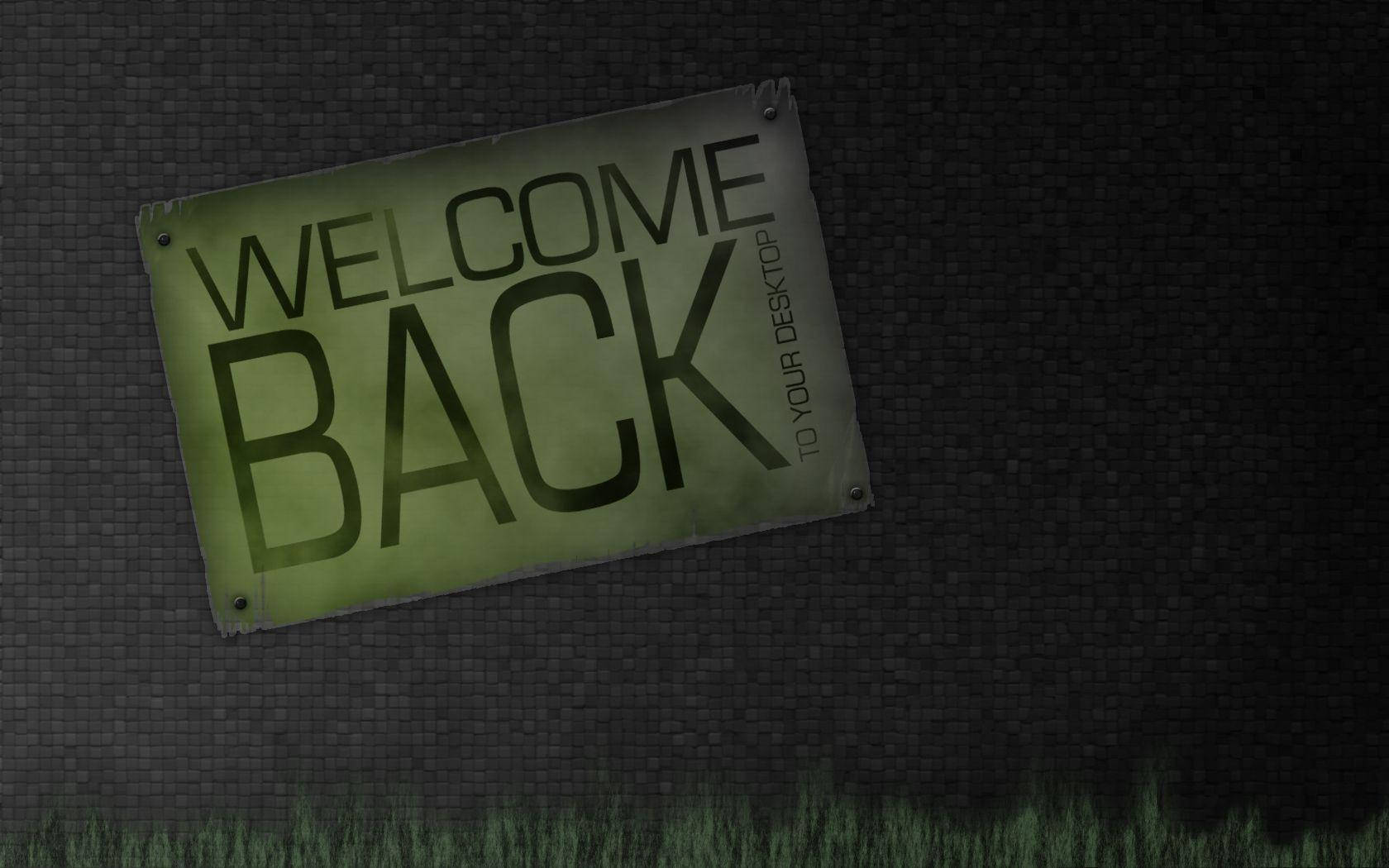 Welcome 桌布 壁紙 — 一個褪色的綠色標牌，上面寫著「WELCOME BACK TO YOUR DESKTOP」，釘在深色紋理牆上，下方有草探出。