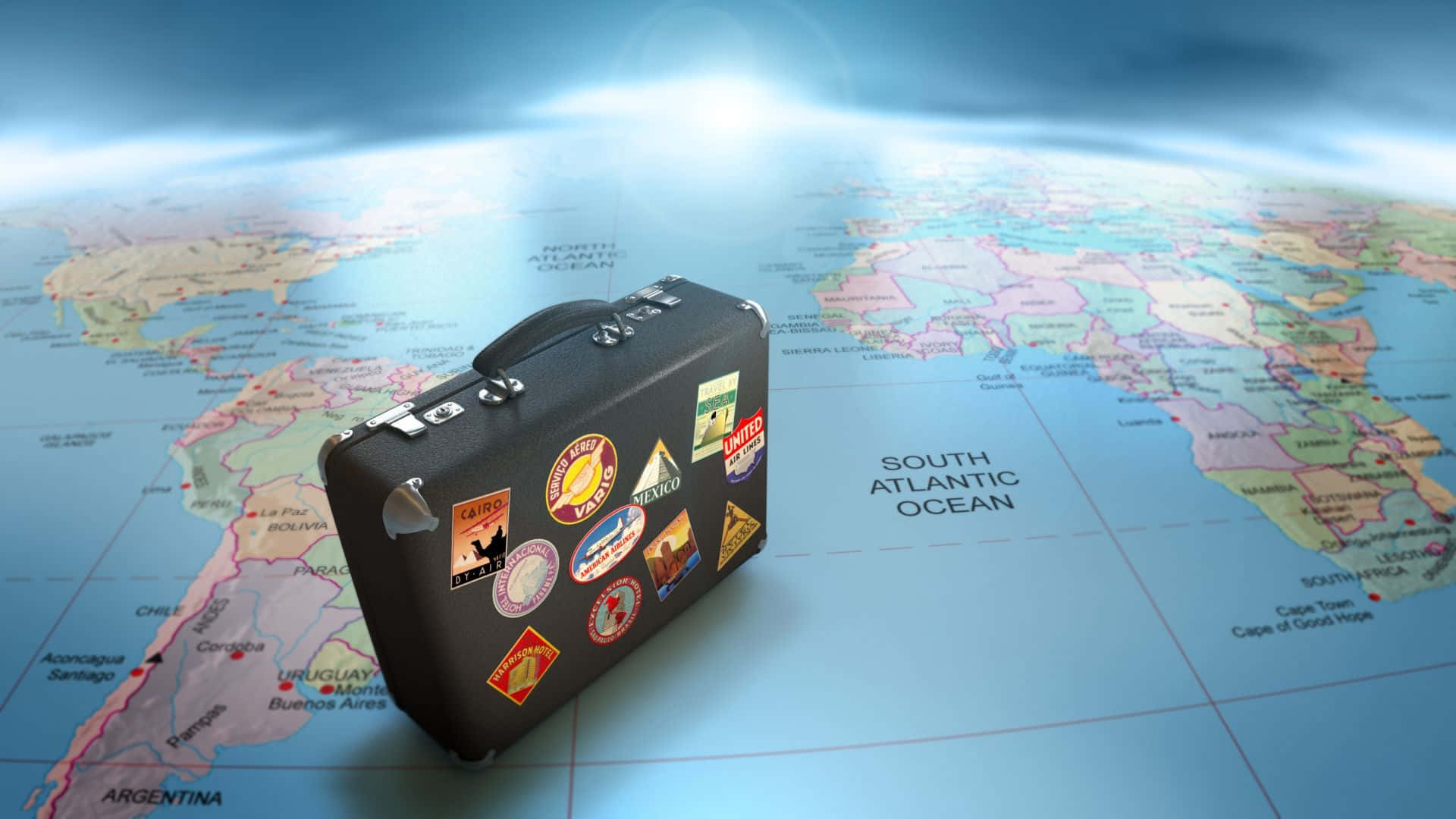Travel Desktop 桌布 壁紙 — 一個覆蓋著旅行貼紙的復古手提箱放在一個帶有發光藍色地平線的世界地圖上。