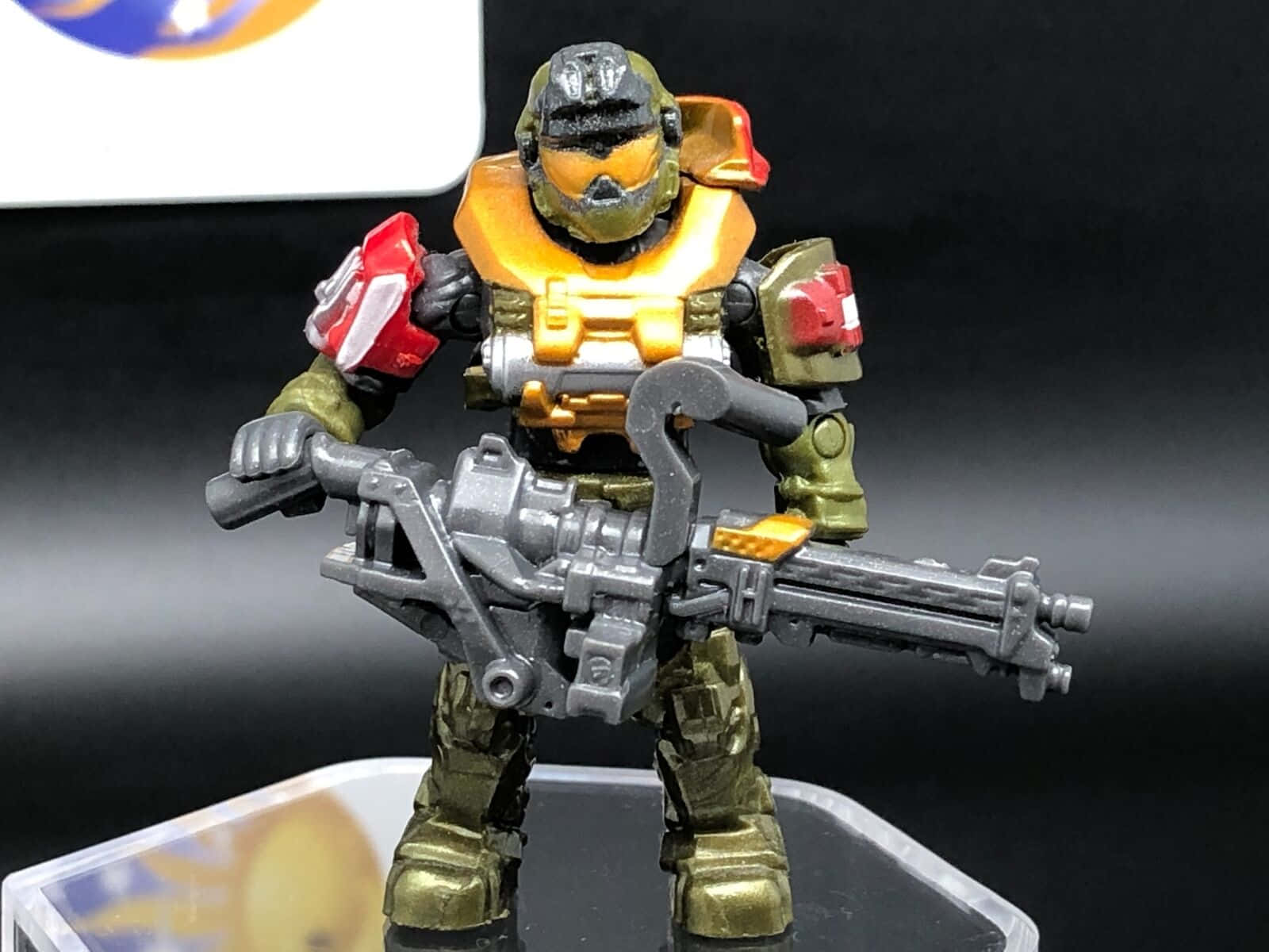 Jorge-052 桌布 壁紙 — 一個詳細的Halo Master Chief綠色盔甲可動人偶，在深色漸變背景前手持重型武器。