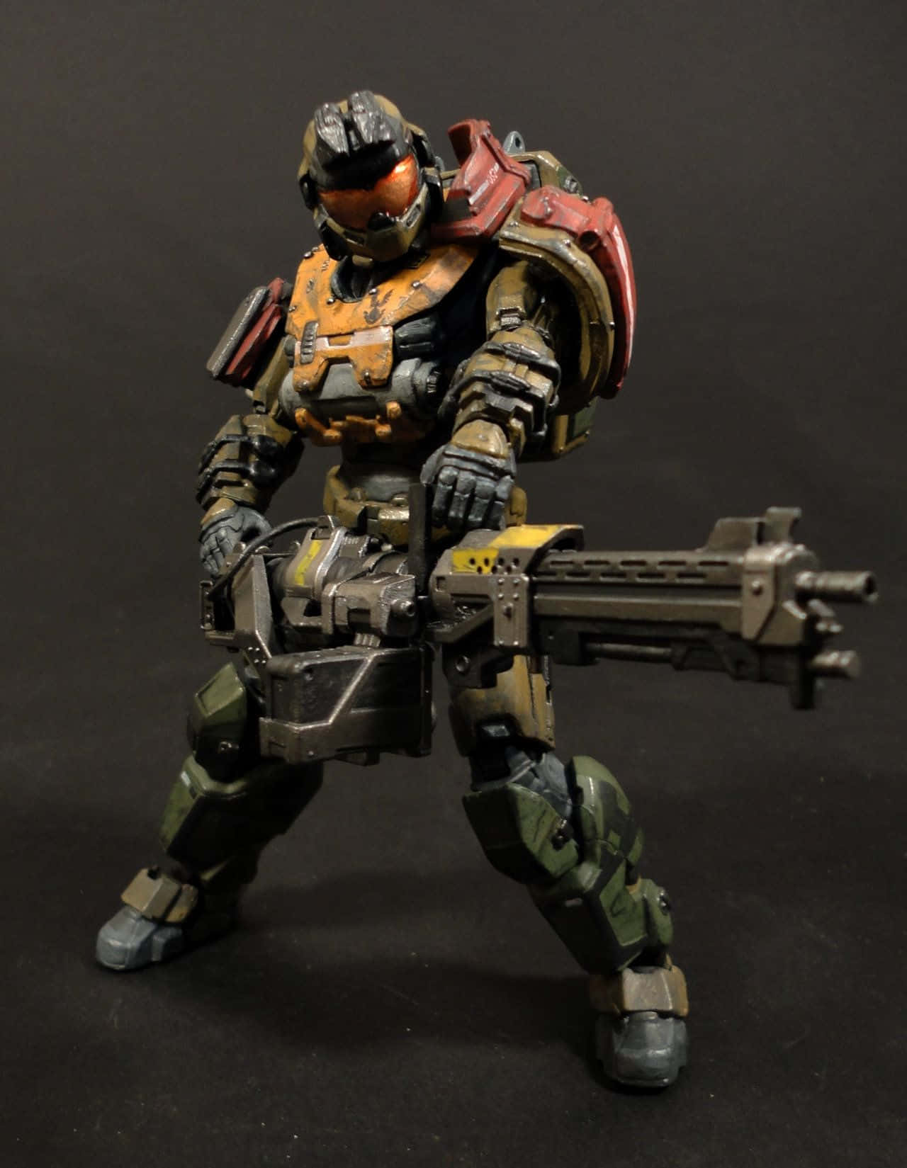 Jorge-052 桌布 壁紙 — 一個詳細的Halo Master Chief可動人偶，以戰鬥姿態手持重型武器，背景為深色。