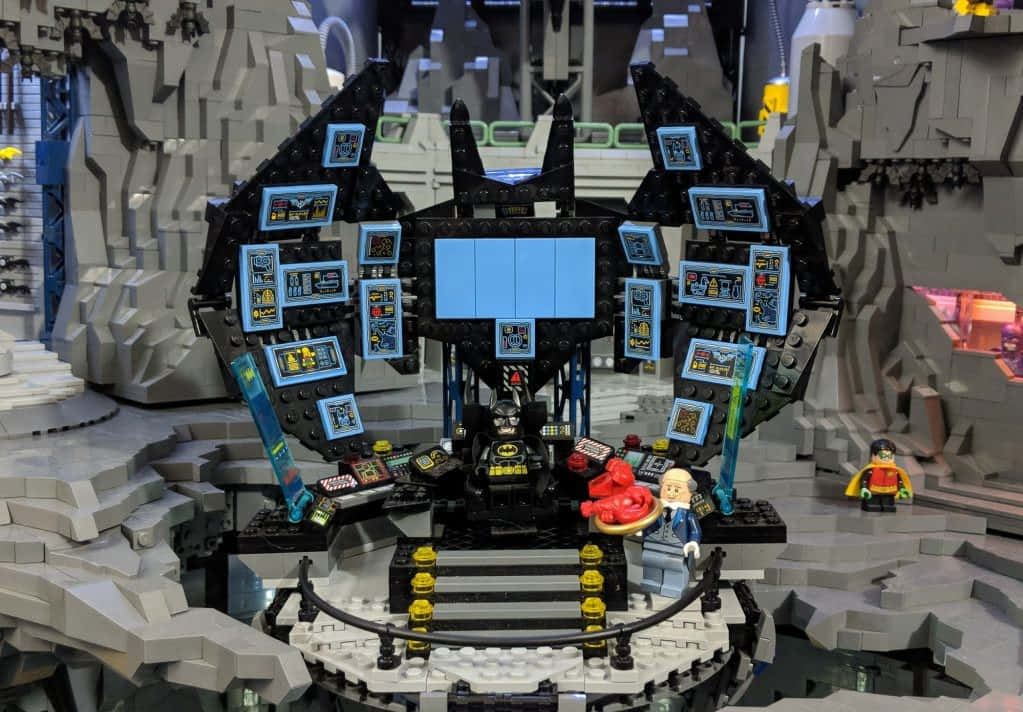 Batcave 桌布 壁紙 — 一個詳細的LEGO蝙蝠俠蝙蝠洞控制室，設有螢幕和人物，位於岩石洞穴中。
