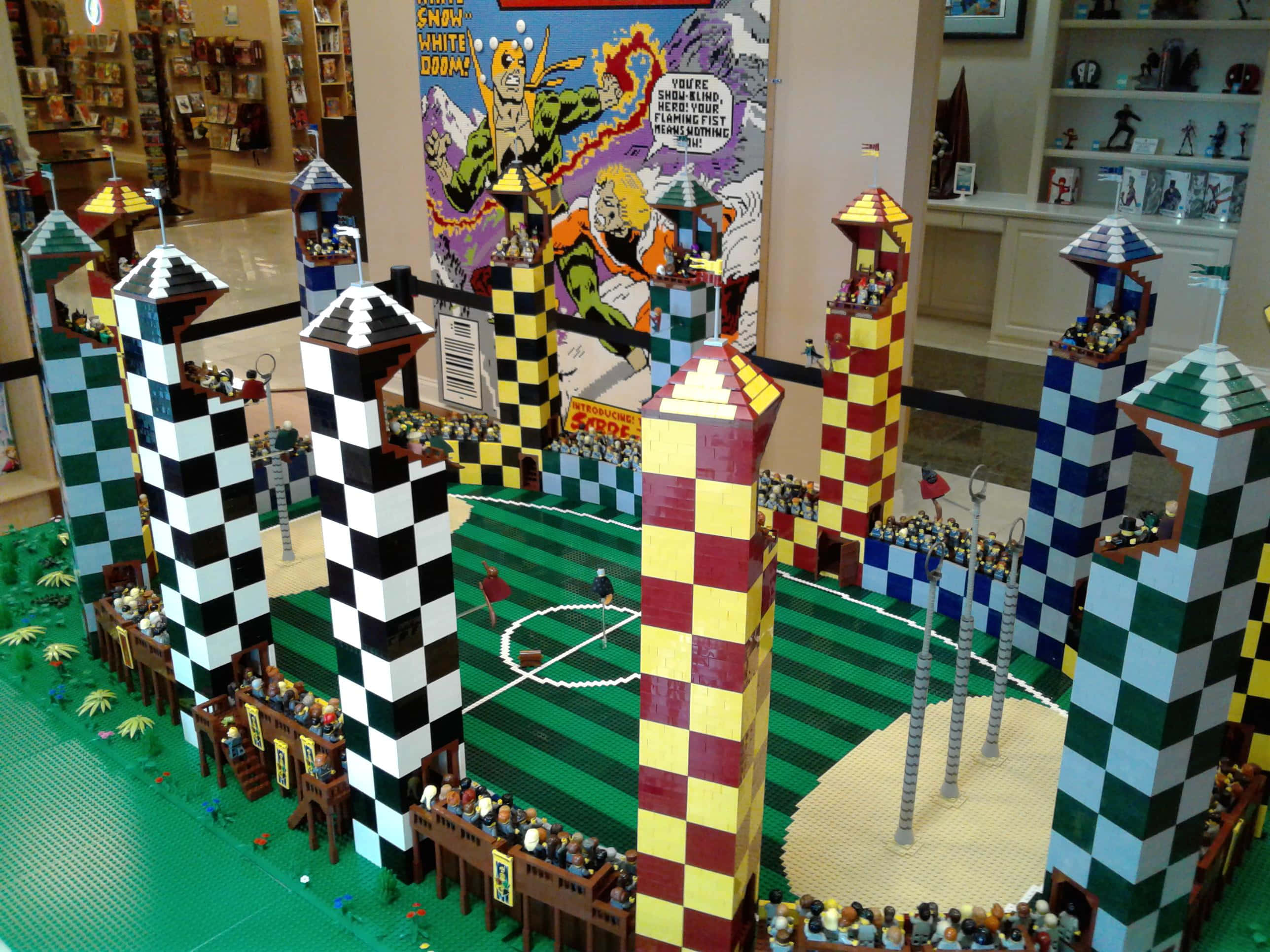 Quidditch 桌布 壁紙 — 一個詳細的LEGO魁地奇球場模型，帶有格子塔和歡呼的觀眾。