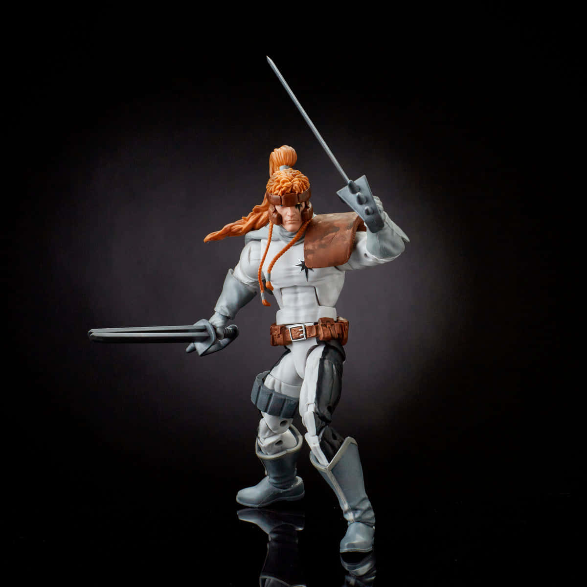 Shatterstar 桌布 壁紙 — 一個詳細的動作人偶，展示一位橙色頭髮、手持雙劍的戰士，在深色漸變背景前擺出姿勢。