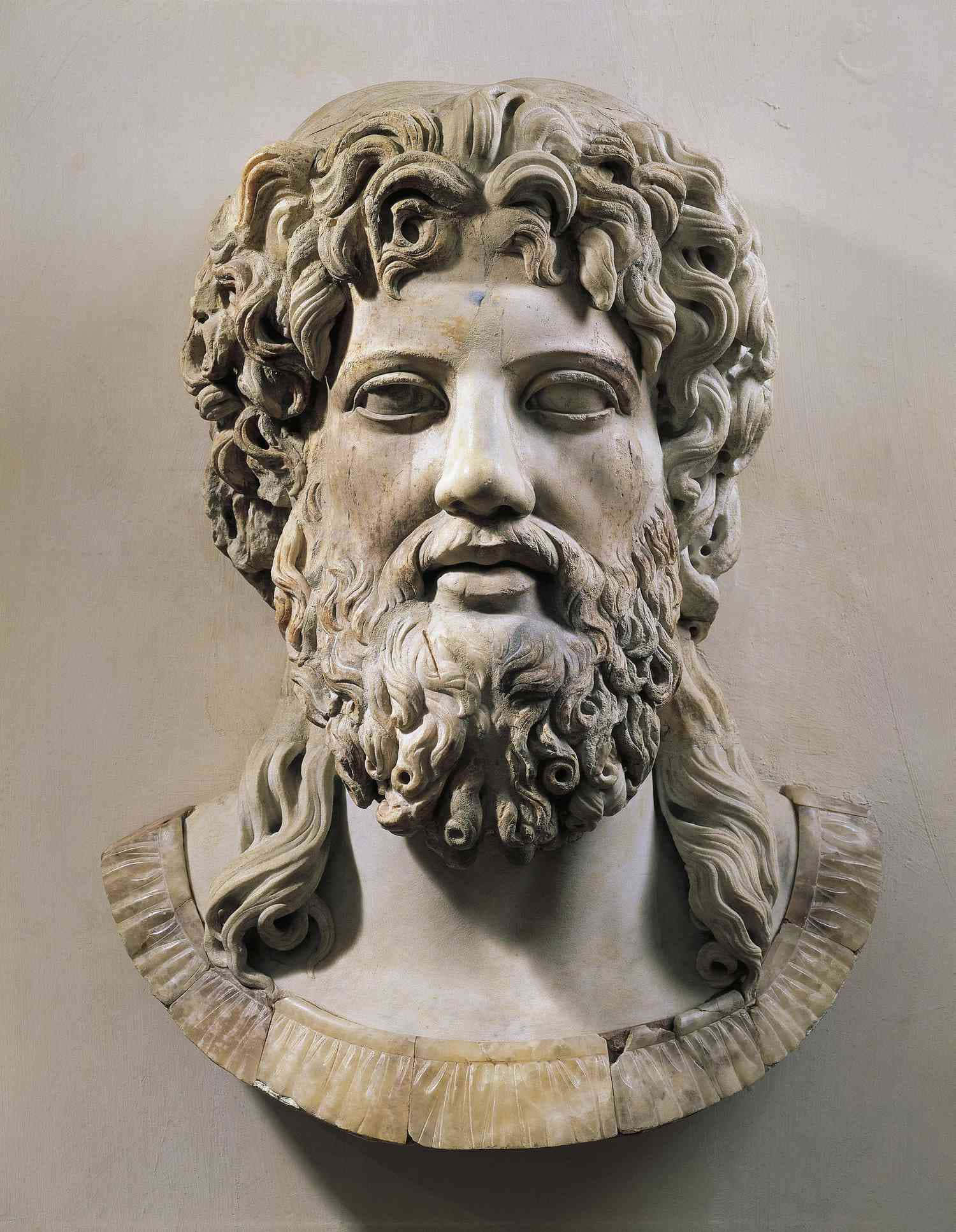 greek 桌布 壁紙 — 一個詳細的大理石半身像，描繪一位留著鬍鬚、捲髮、披肩領的男子，背景是素牆。