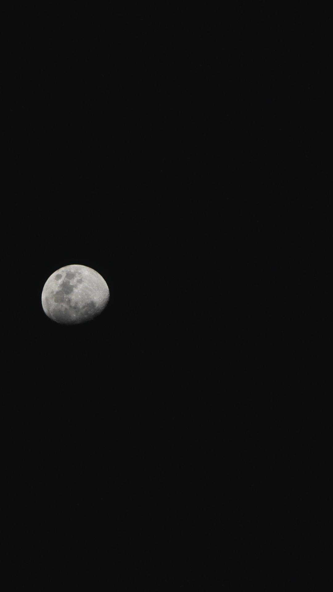 iPhone 桌布 壁紙 — 一個詳細的彎月在沒有星星的深黑色夜空中柔和發光。