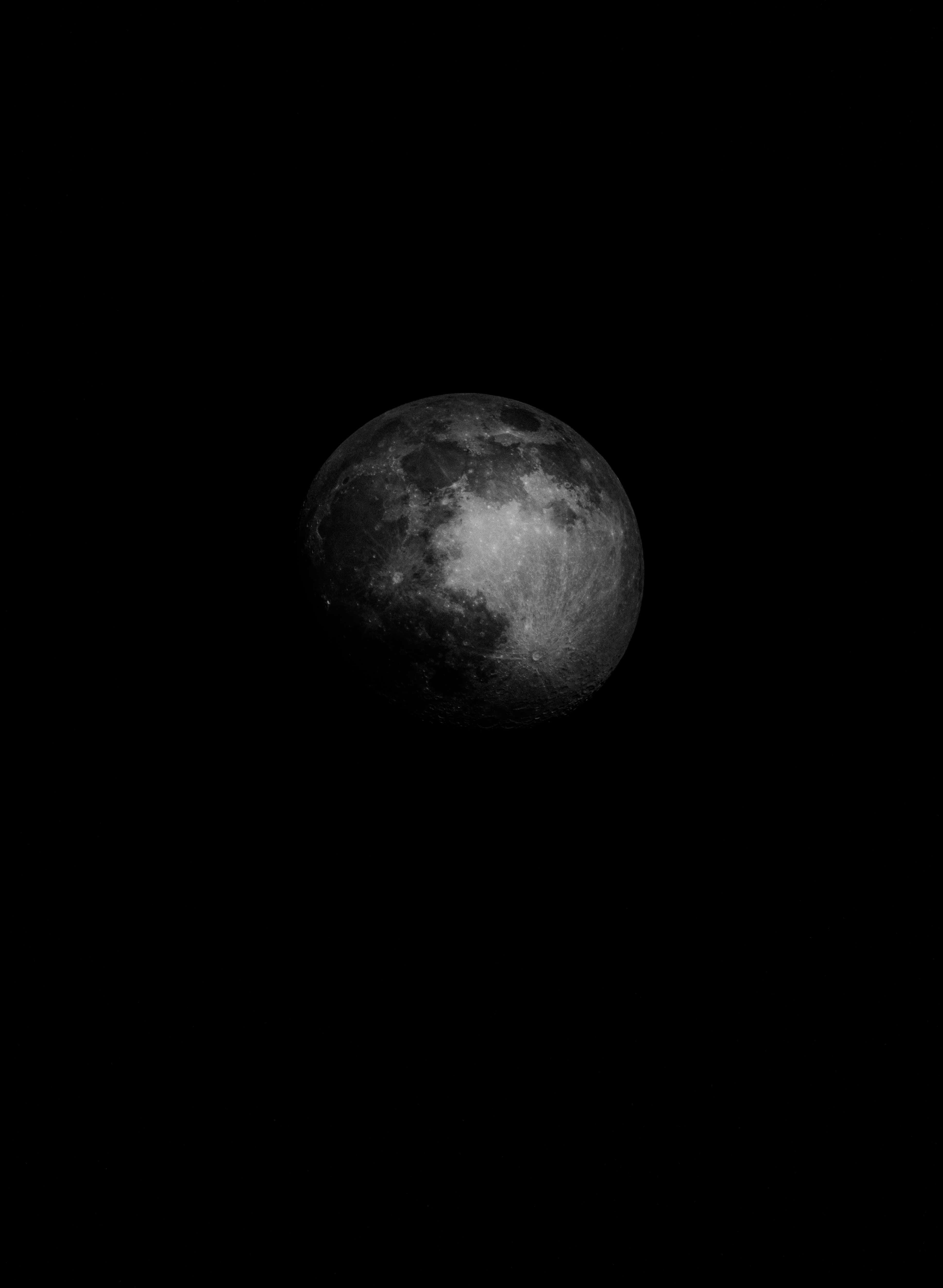 Dark Moon 桌布 壁紙 — 一個詳細的灰階月亮孤獨地懸掛在漆黑的虛空中，其隕石坑和月海清晰可見。