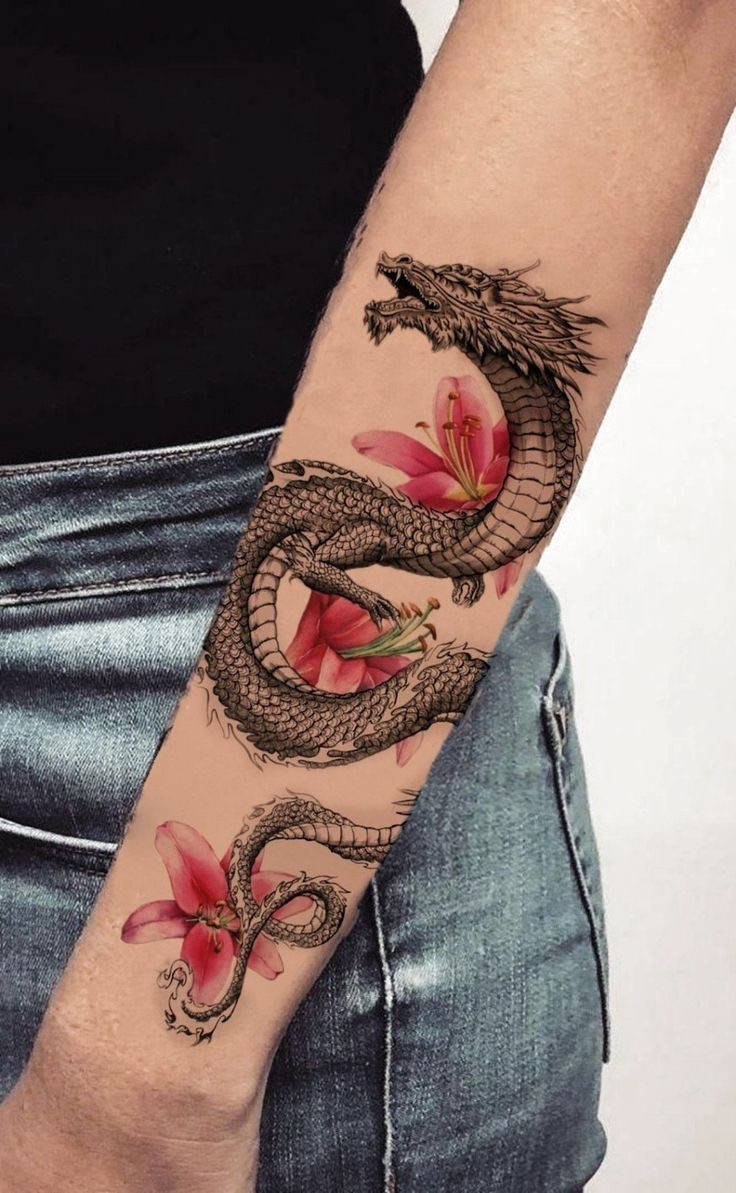 Japanese Dragon Tattoo 桌布 壁紙 — 一個詳細的紋身，描繪一條盤繞的龍與鮮豔的粉紅色百合交織在一起，纏繞在一個人的前臂和手腕上。