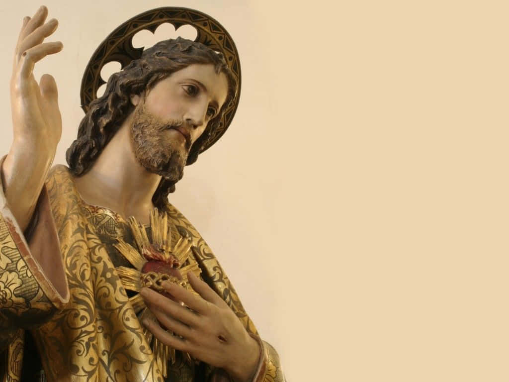 Jesus Christ 桌布 壁紙 — 一個詳細的耶穌基督雕像，帶有金色光環和華麗長袍，手持祂的聖心。