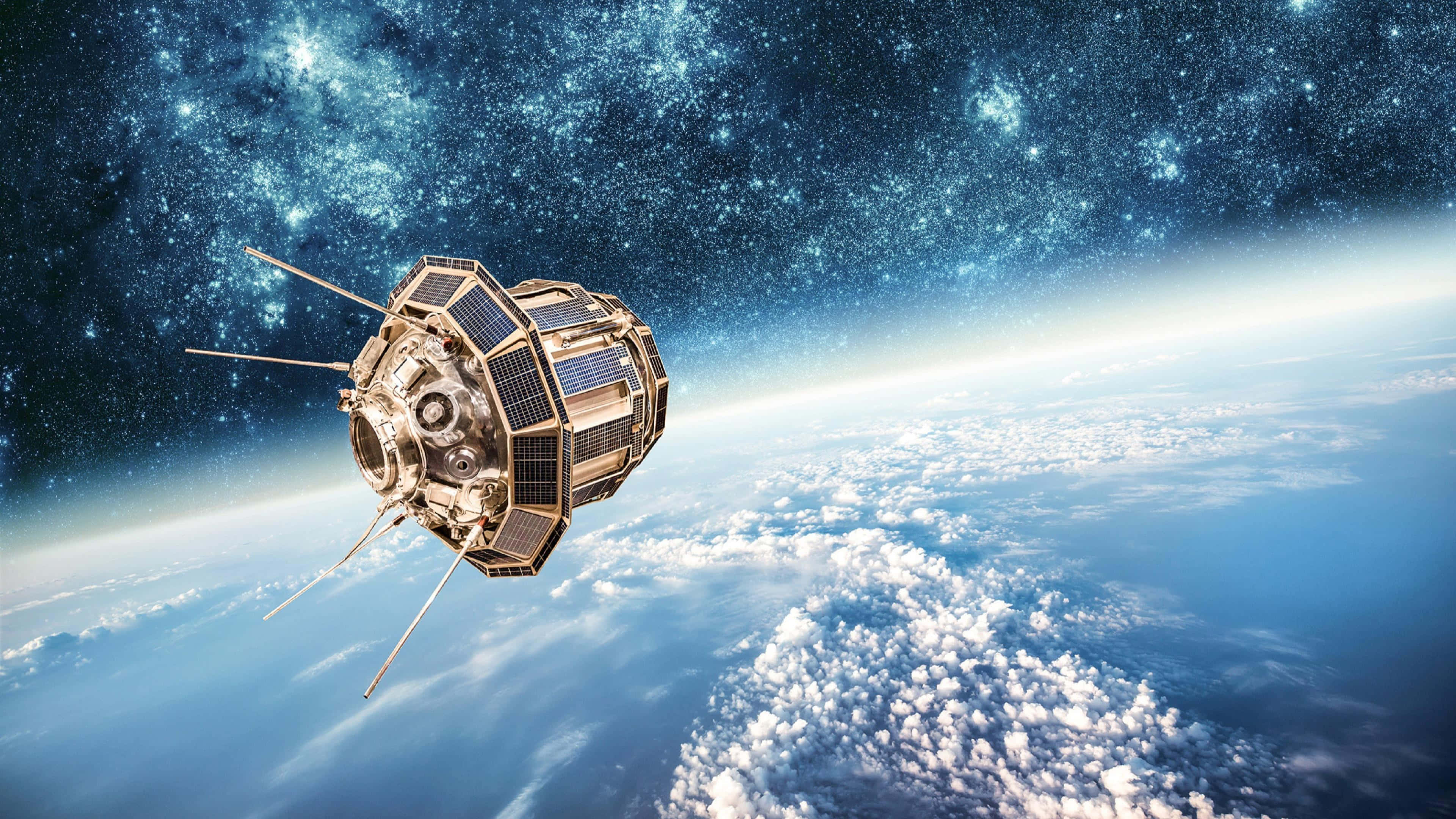 Satellite 桌布 壁紙 — 一個詳細的衛星在星光燦爛的宇宙背景下環繞地球運行，並帶有發光的大氣層。