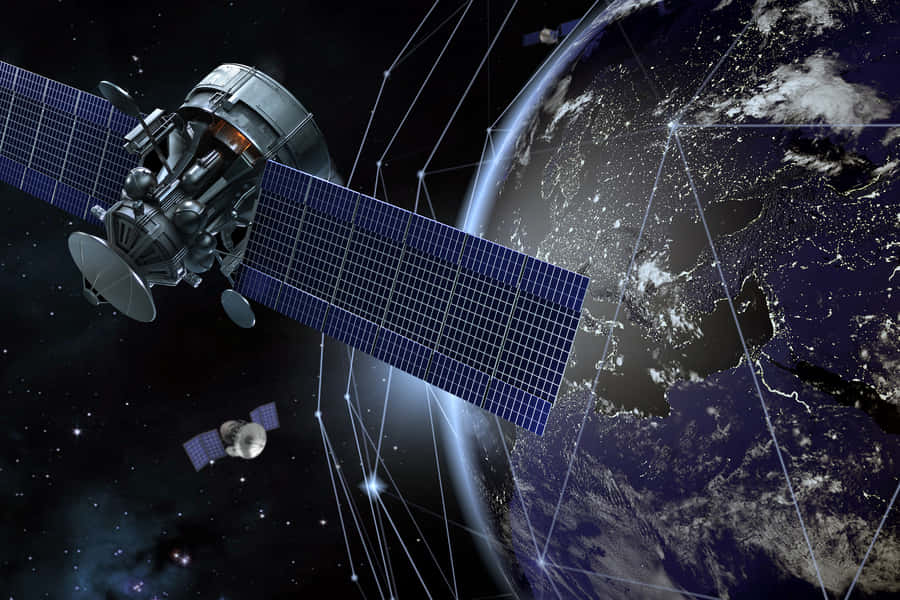 Satellite Technology 桌布 壁紙 — 一個詳細的衛星帶有太陽能板在夜間繞地球運行，下方發光的城市燈光由數位線路連接。