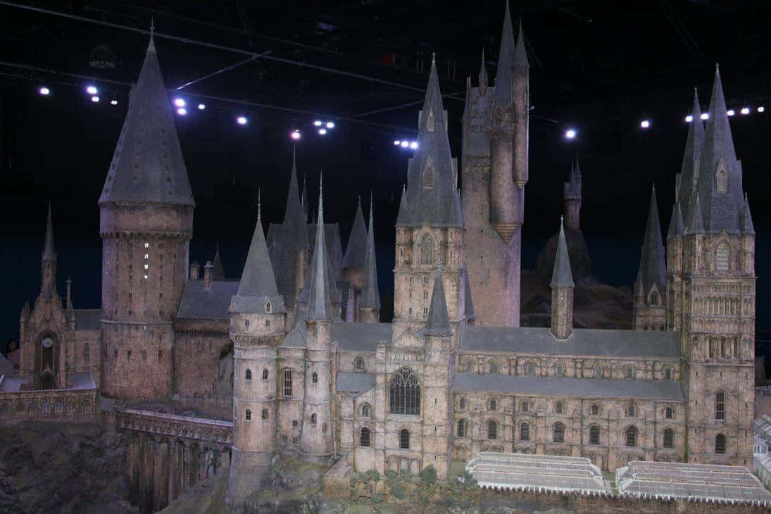 Hogwarts Castle 桌布 壁紙 — 一個詳細的霍格華茲城堡微型模型，在黑暗背景下被聚光燈照亮。