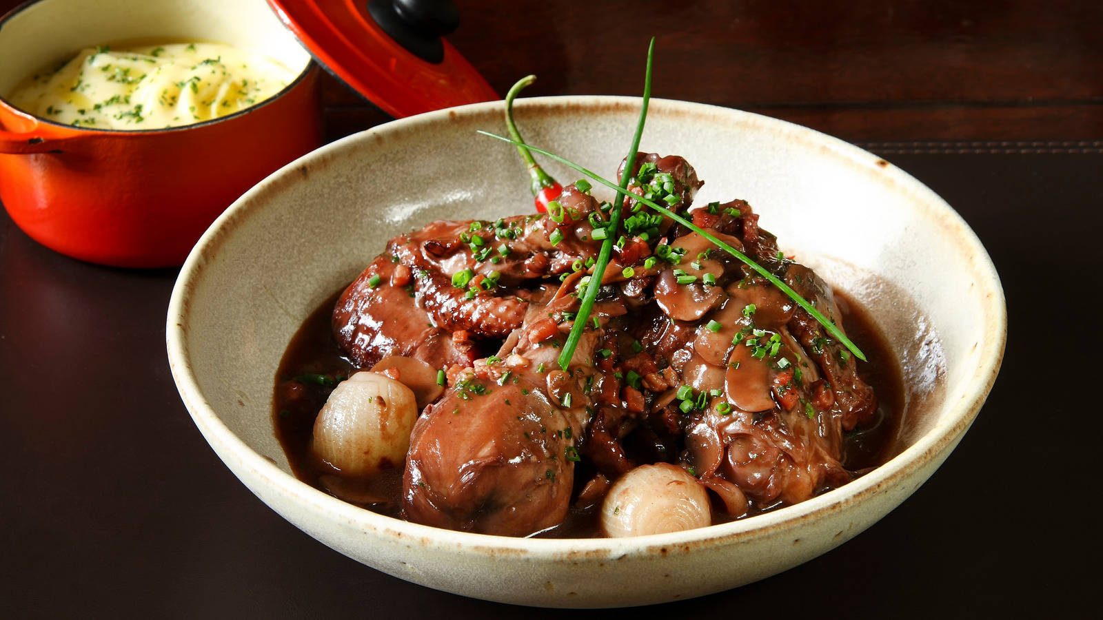 Food Photography 桌布 壁紙 — 一個豐富的燉菜，包含燉肉、蘑菇和珍珠洋蔥，上面裝飾著細香蔥，放在一個質樸的陶瓷碗中。
