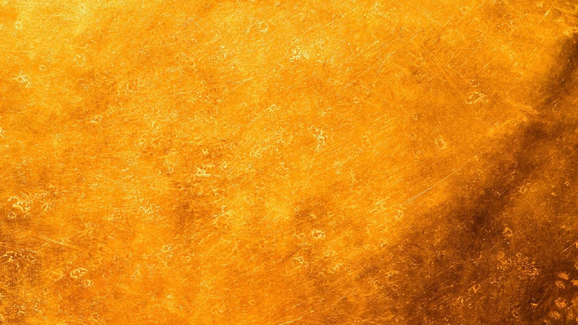 Yellow Grunge 桌布 壁紙 — 一個豐富紋理的金色表面，帶有微妙的刮痕和溫暖的漸變色調。