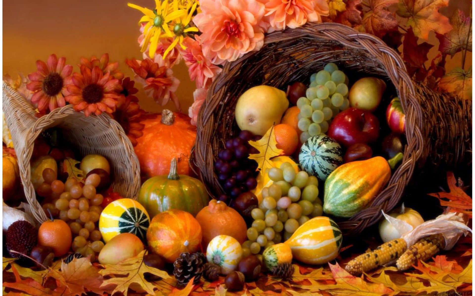 Beautiful Thanksgiving 桌布 壁紙 — 一個豐盛的秋季豐收展示，南瓜、葡萄、蘋果和色彩繽紛的花朵從編織籃子中溢出，周圍散落著落葉。