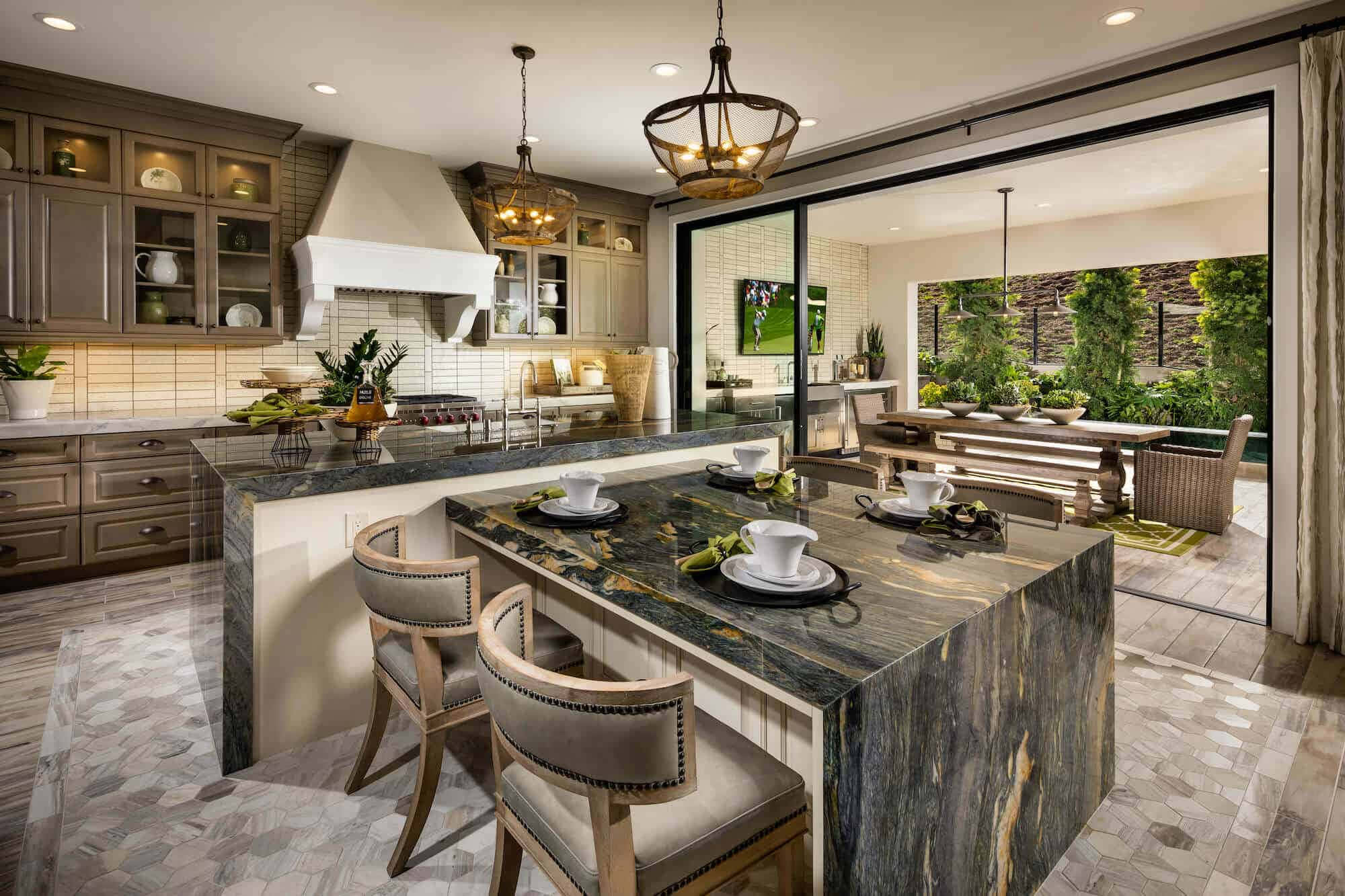 Kitchen Design 桌布 壁紙 — 一個豪華現代廚房，設有大理石中島和玻璃門，通往綠色戶外用餐區。
