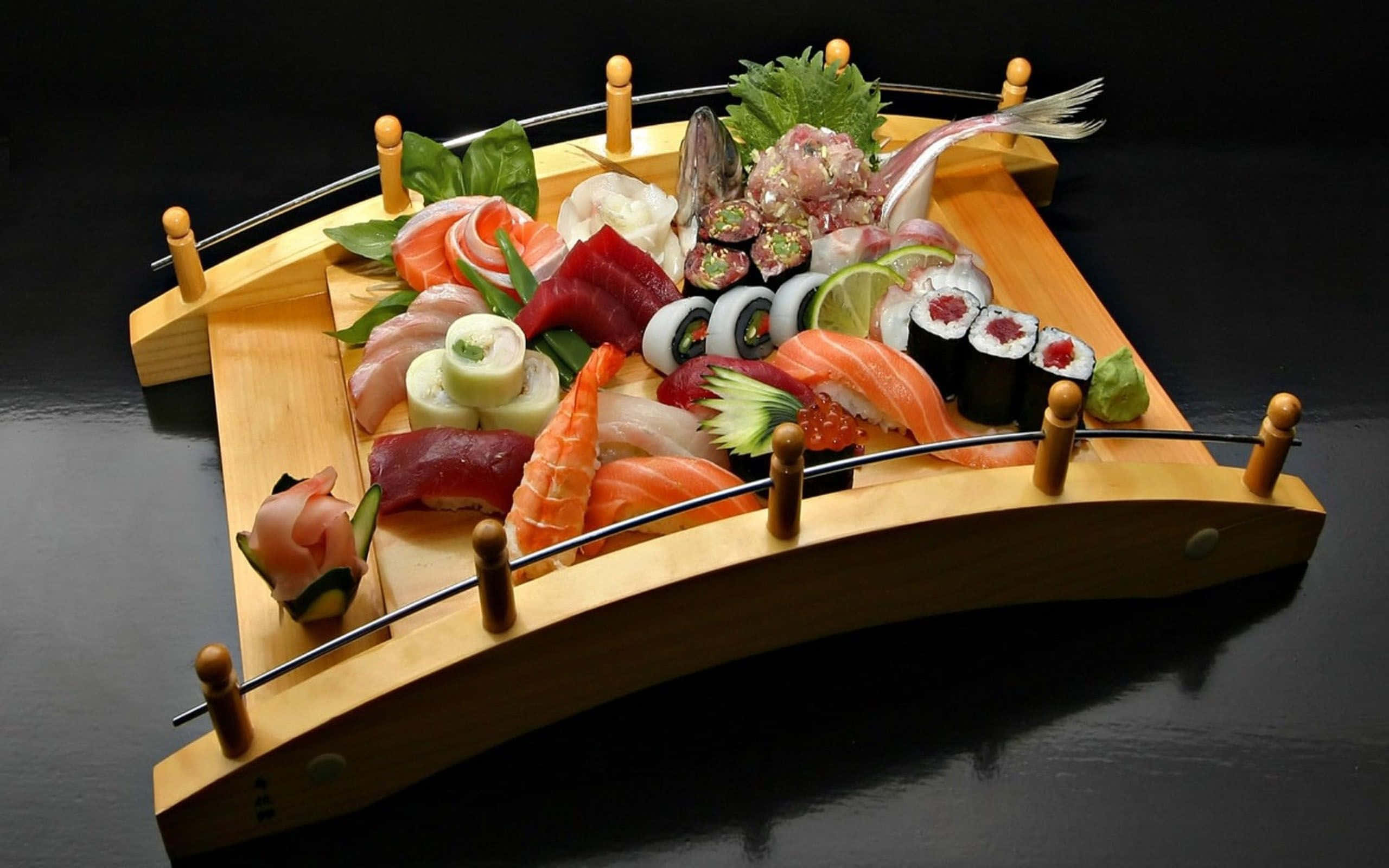 Delicious Food 桌布 壁紙 — 一個豪華的壽司拼盤，藝術地擺放在一個木橋形托盤上，搭配鮮豔的魚和裝飾，背景為深色。