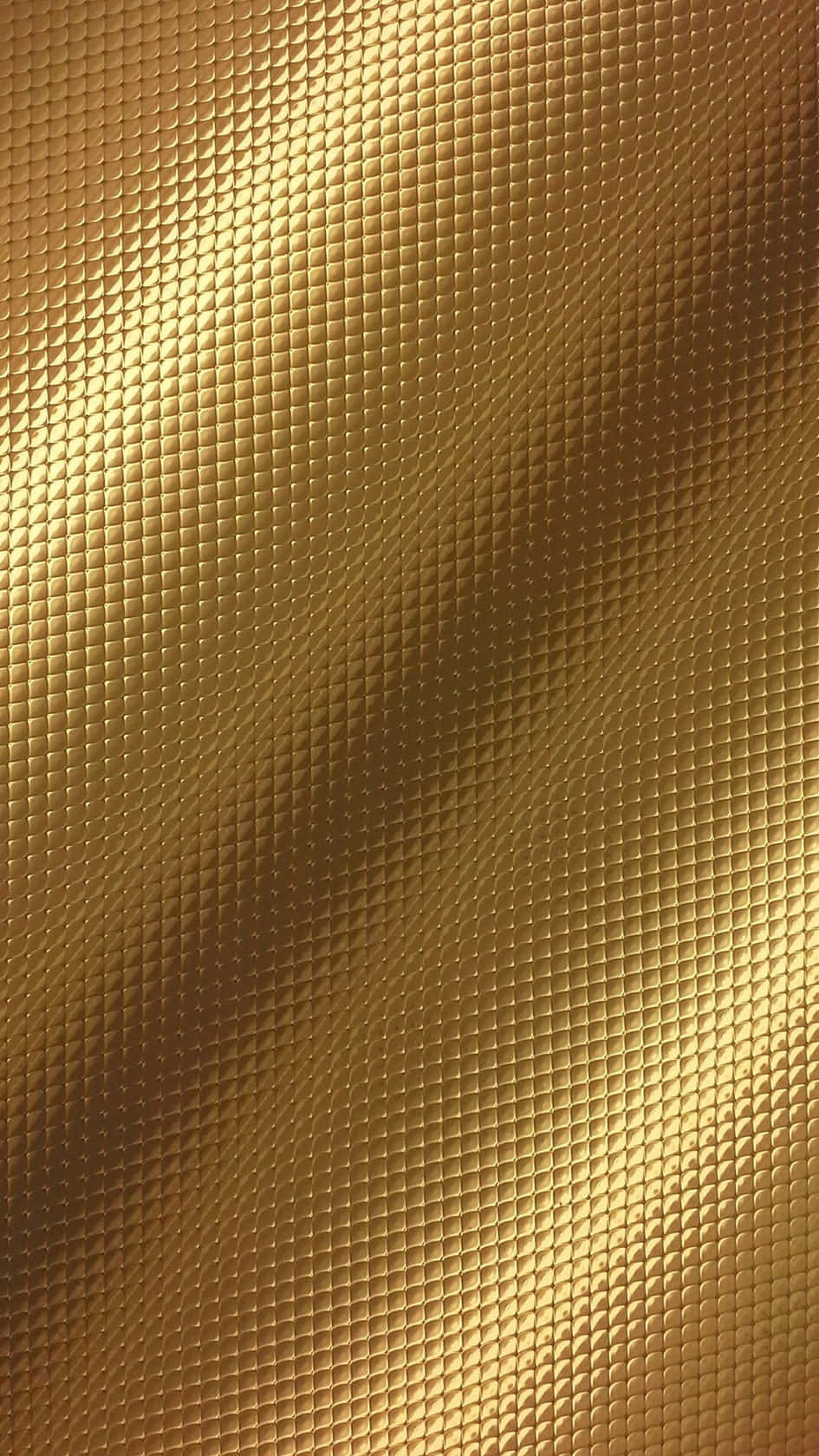 Shiny Gold 桌布 壁紙 — 一個豪華的金色表面，帶有重複的鑽石圖案和柔和的漸變燈光。