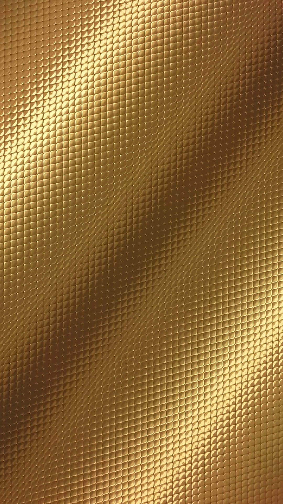 Golden 桌布 壁紙 — 一個豪華金色表面的特寫，帶有重複的鑽石圖案和柔和漸變燈光。