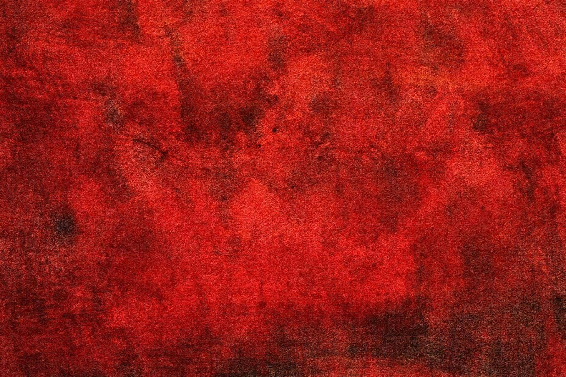 Red Texture 桌布 壁紙 — 一個質感豐富的紅色表面，帶有深色污跡和不均勻的筆觸圖案，形成大膽的抽象畫布。
