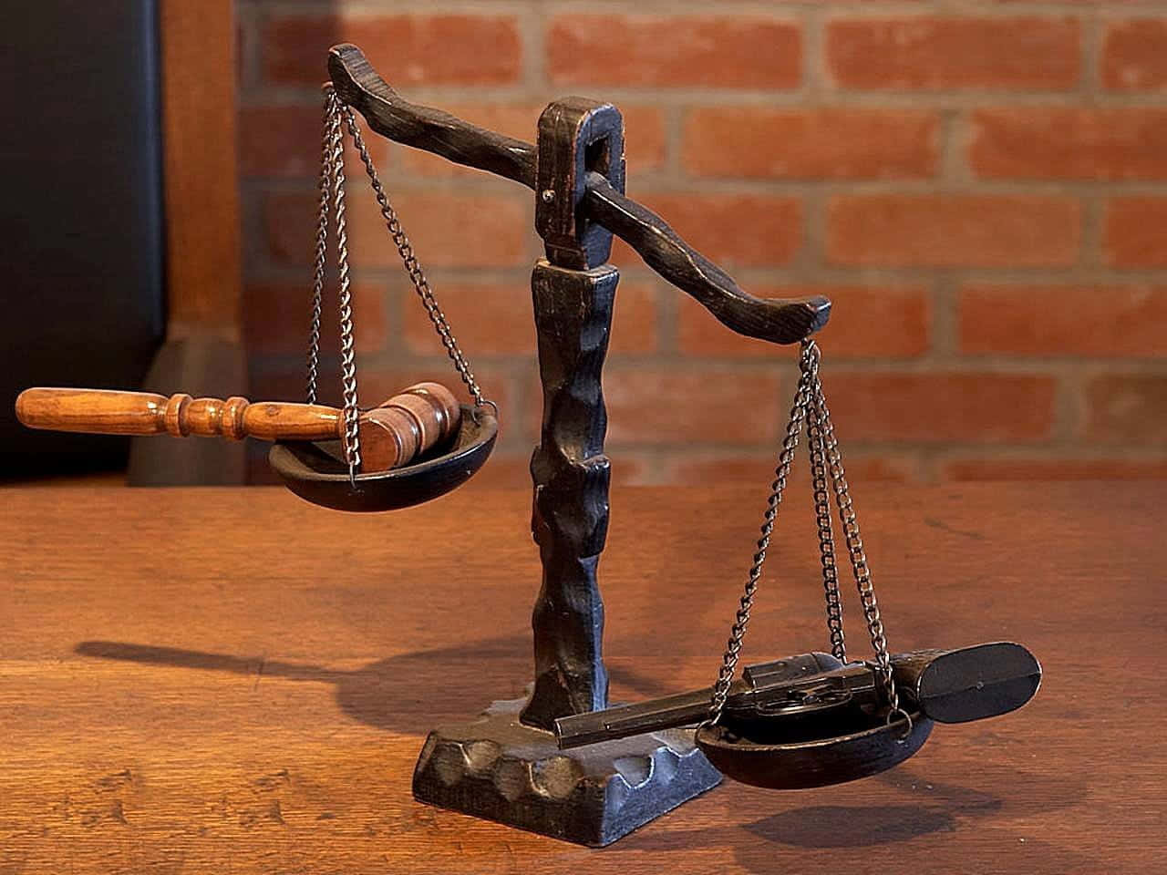 judge 桌布 壁紙 — 一個質樸的木槌放在一個風化的金屬天秤的一側，靠著磚牆，放在木桌上。