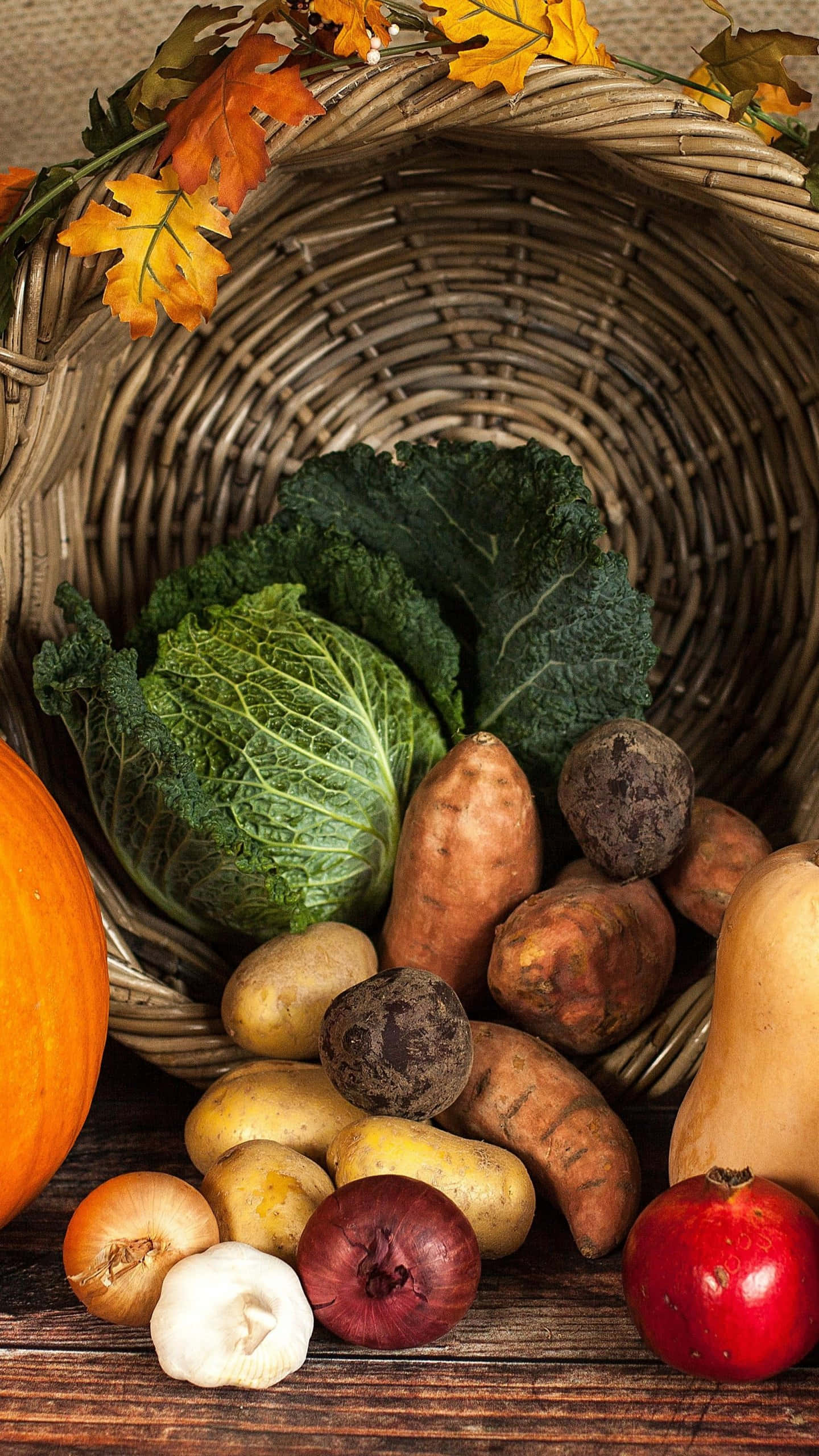 Fall Harvest 桌布 壁紙 — 一個質樸的柳條籃子，裝滿了秋季收成的蔬菜和南瓜，放在木質表面上。