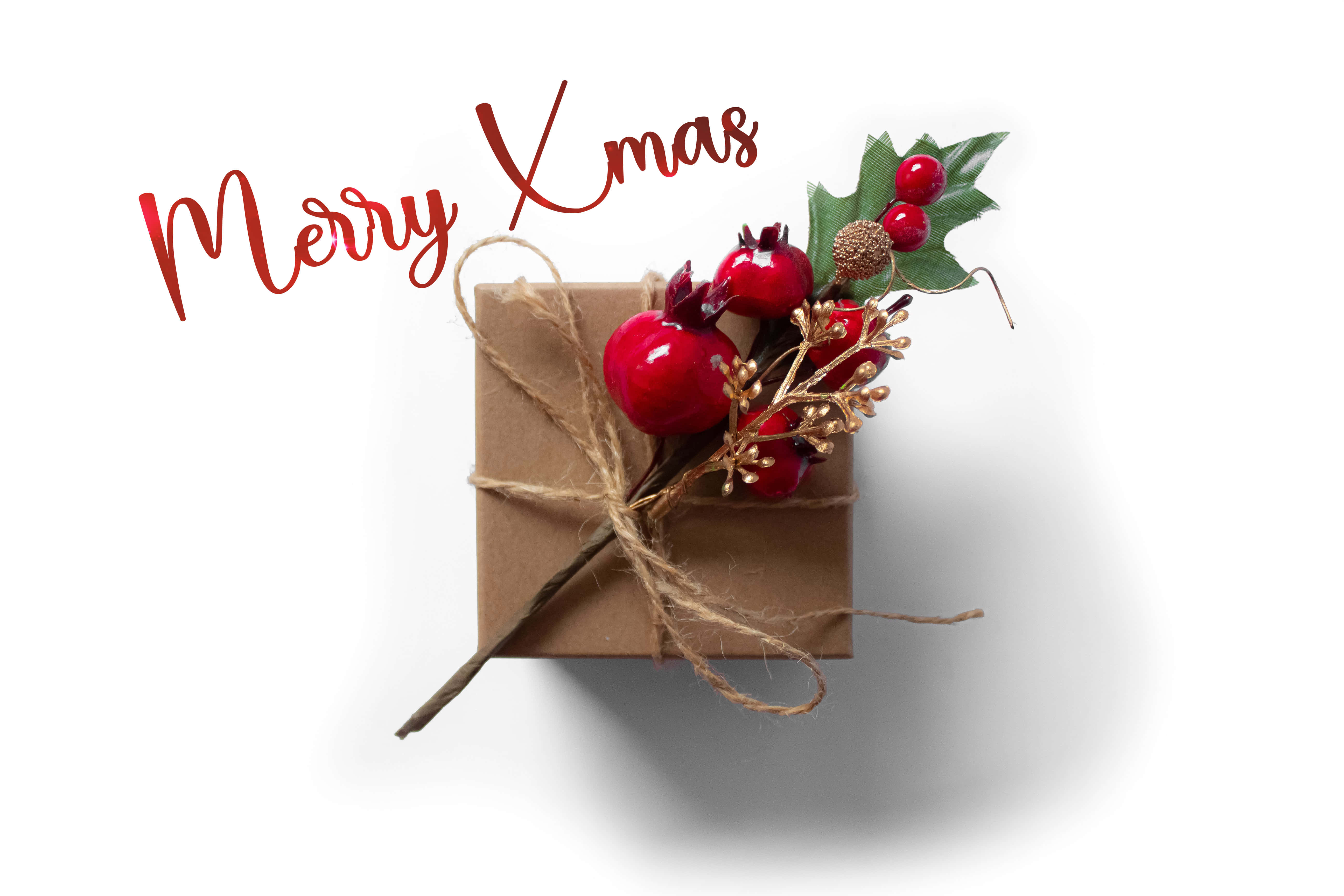 Christmas Gift 桌布 壁紙 — 一個質樸的棕色禮物盒，飾有紅色漿果、綠色冬青和麻繩，背景為純白色，帶有'Merry Xmas'字樣。