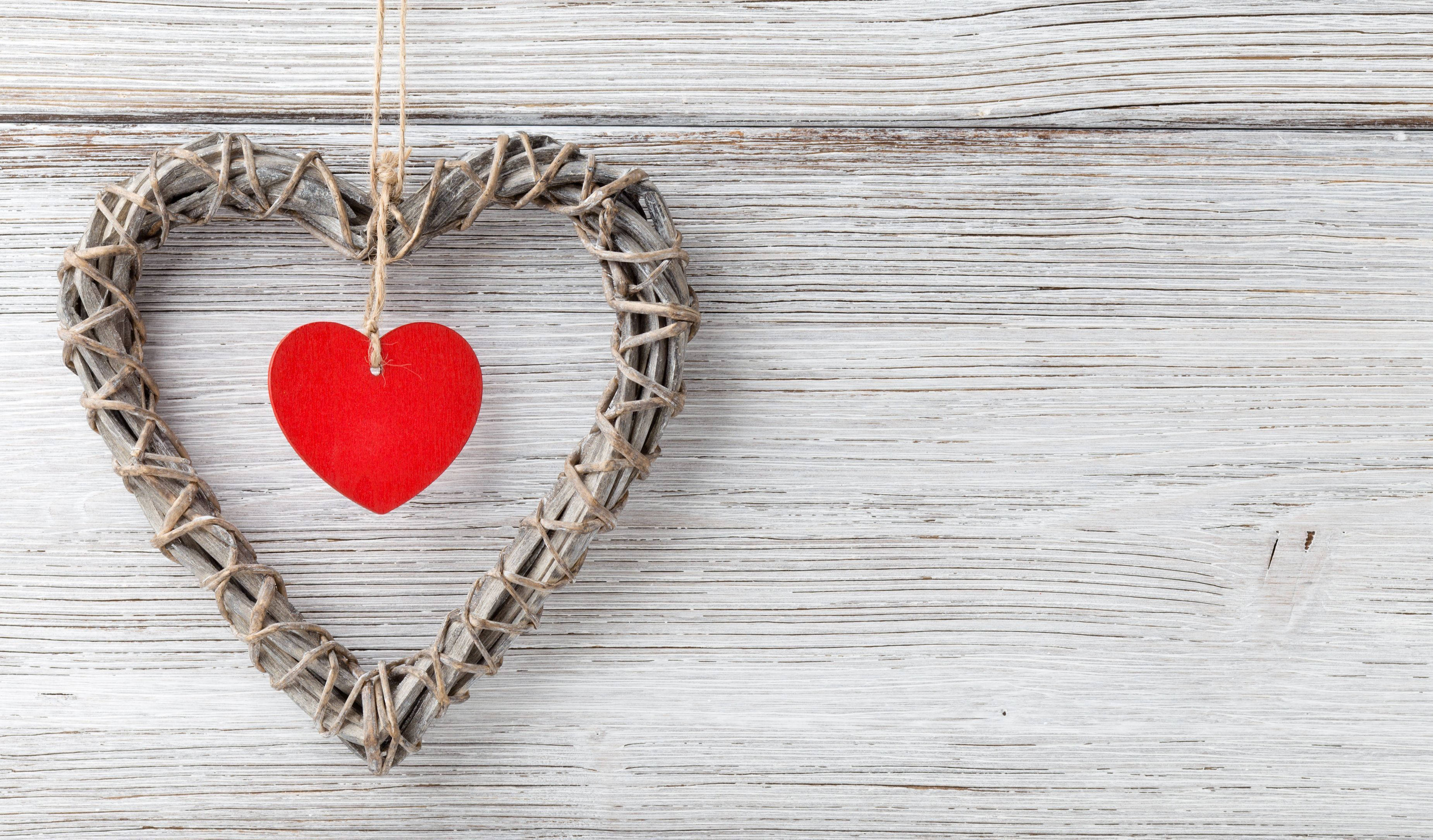 Tumblr Valentines Day 桌布 壁紙 — 一個質樸的編織心形框架掛著一個鮮紅色的氈製心形，背景是風化的白色木板。