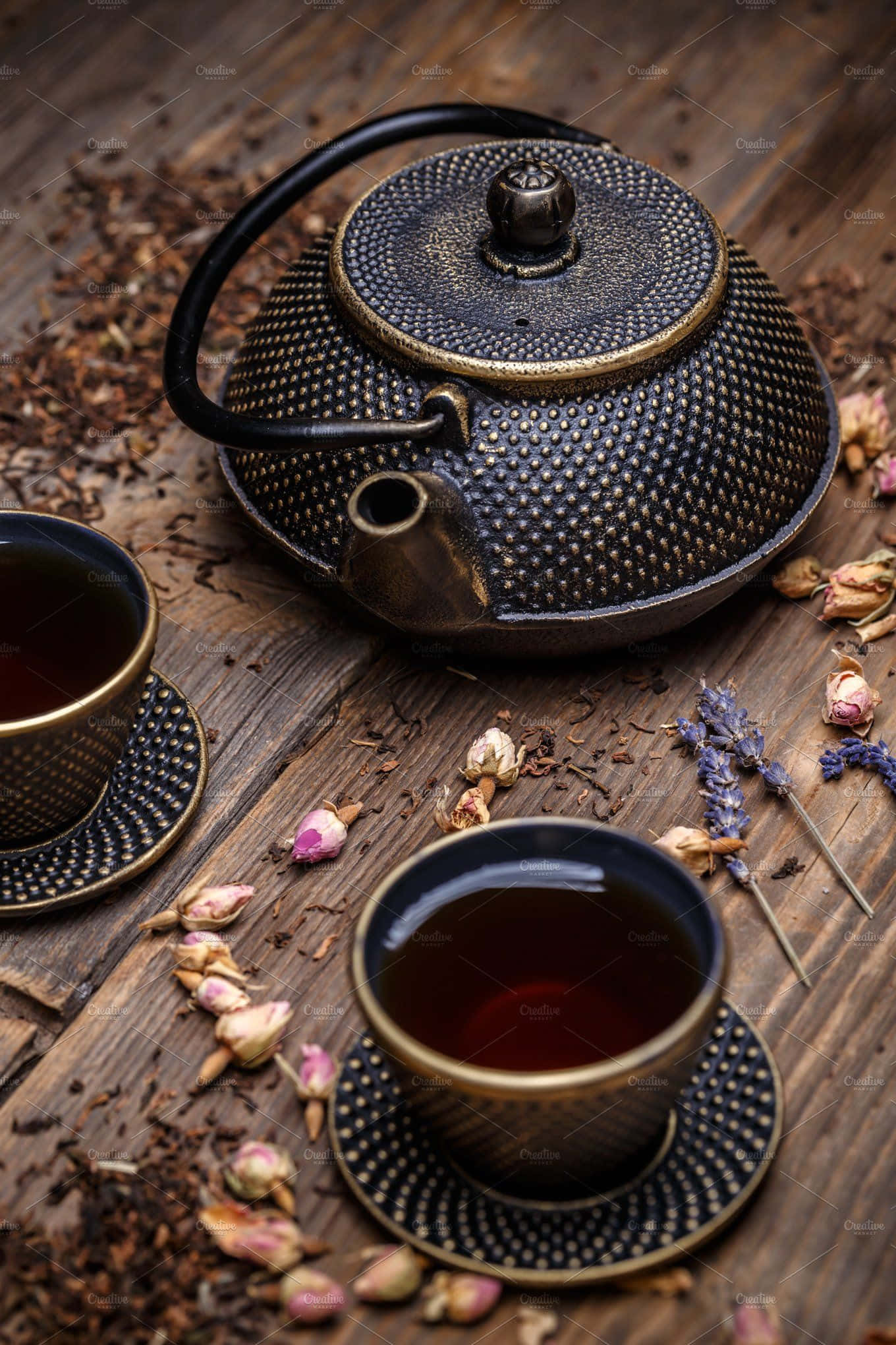 Teatime 桌布 壁紙 — 一個質樸的黑色紋理茶壺和兩杯深色茶放在一張散落著乾玫瑰花瓣和薰衣草的風化木桌上。